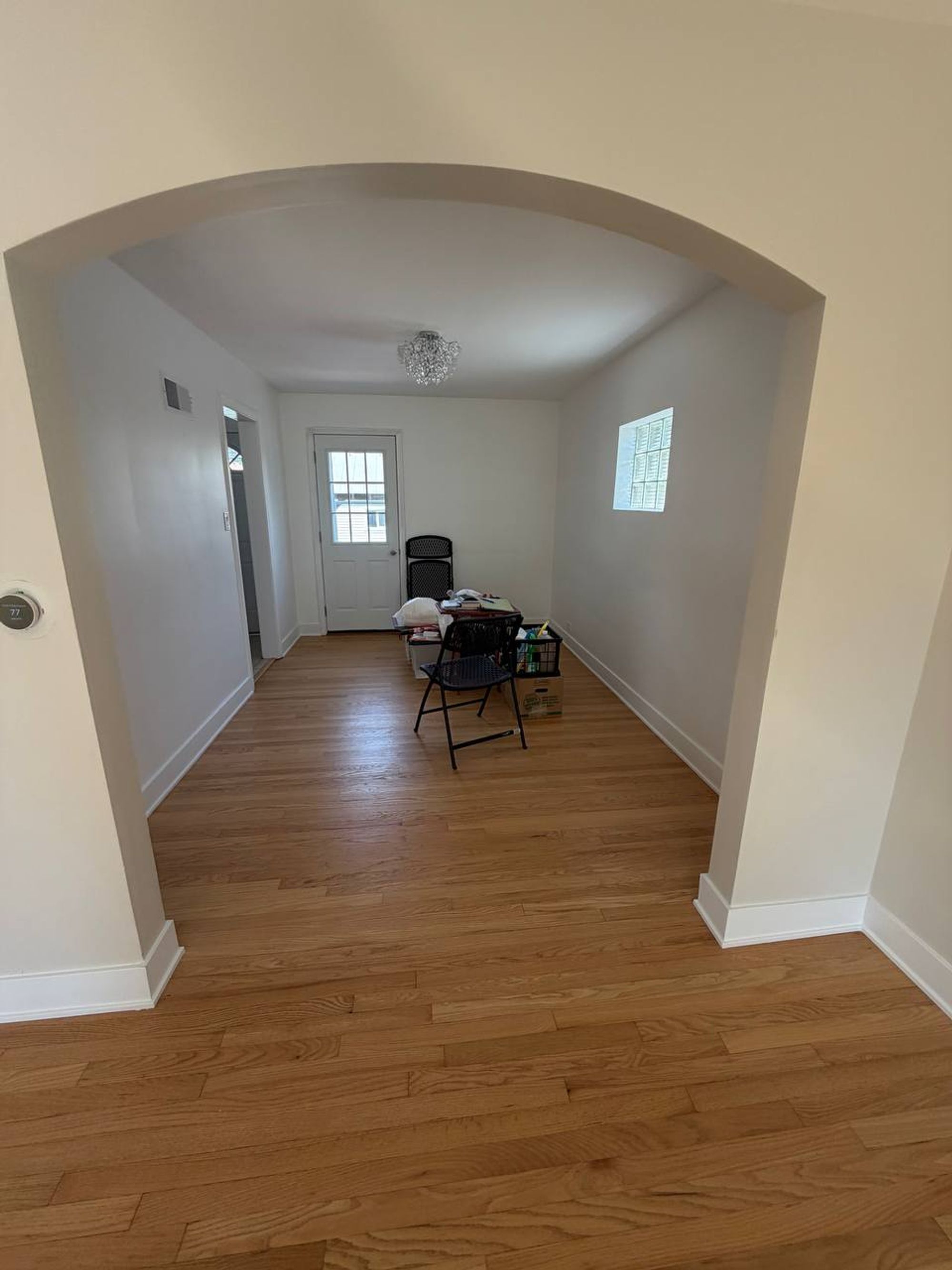 Dining room through an arched doorway with clean oak floors