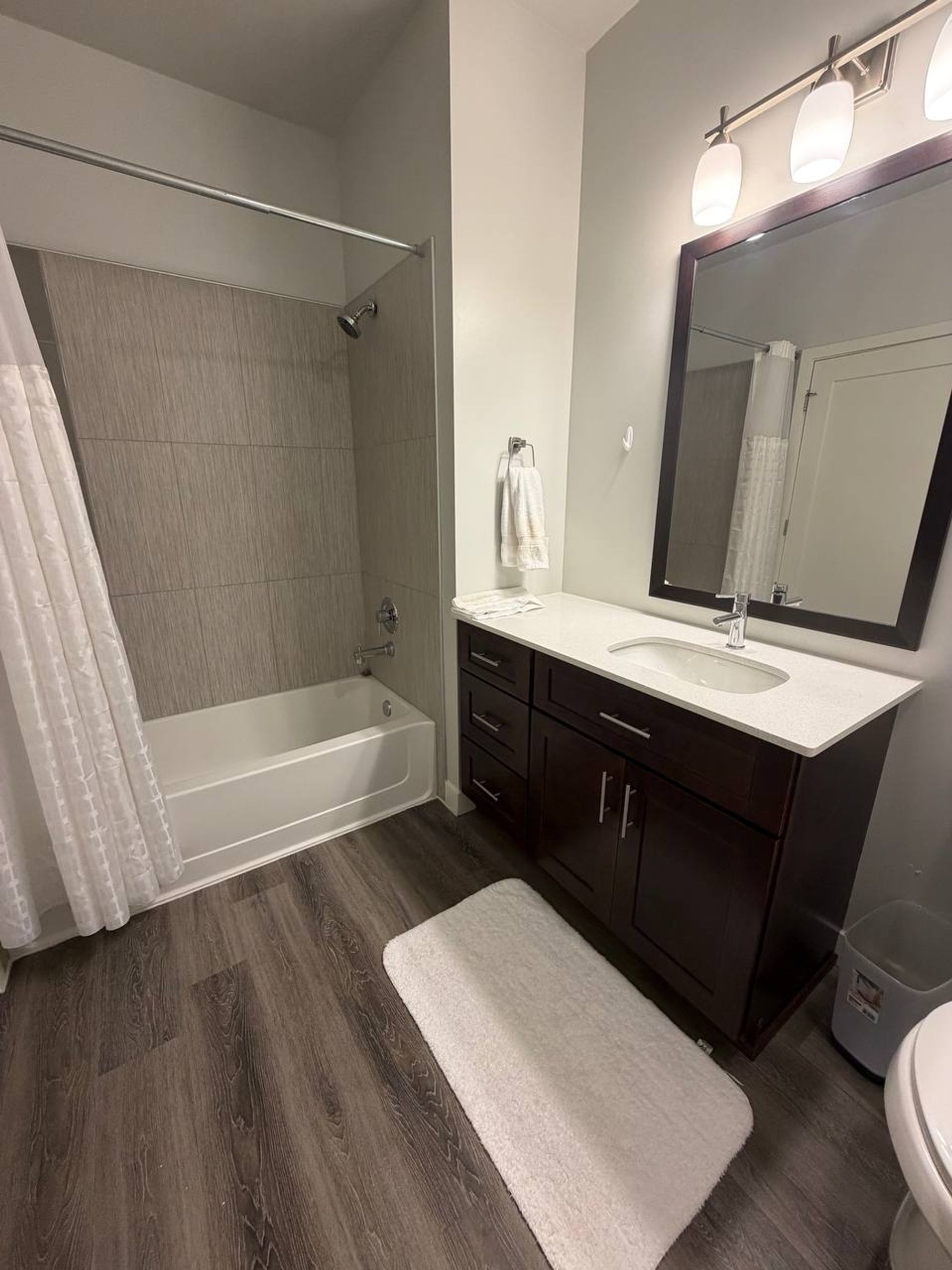Bathroom with a tub, white shower curtain and hand towel on the hook