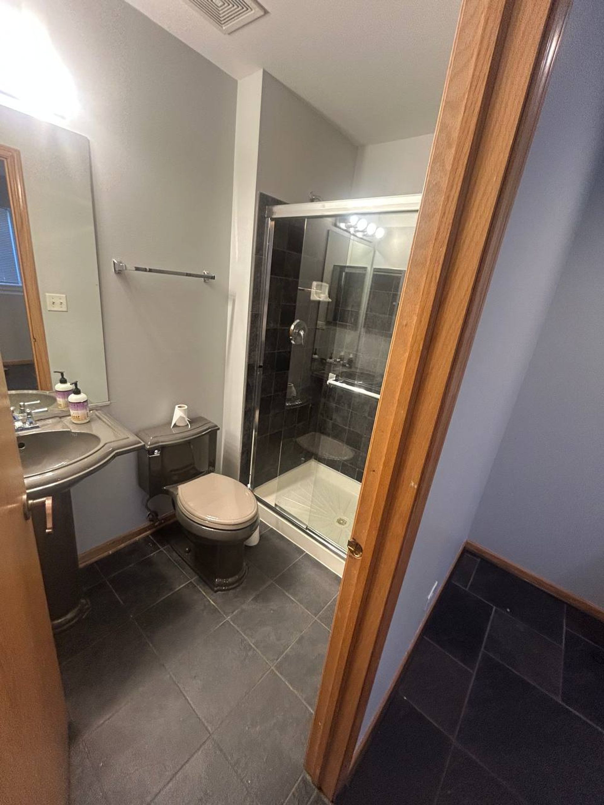Bathroom with dark tile walk-in shower and slate floor