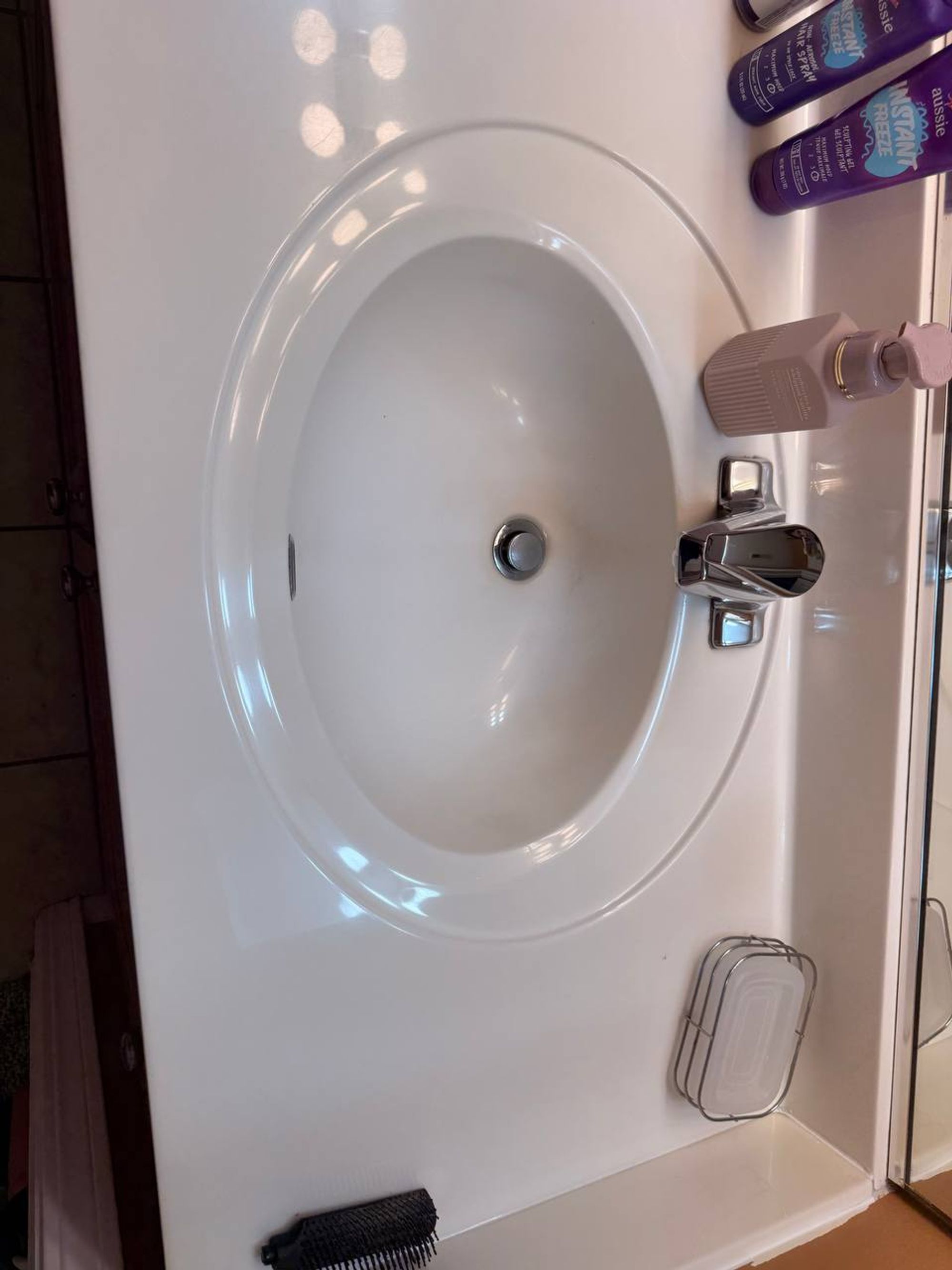 Clean oval sink with chrome faucet on a white vanity top