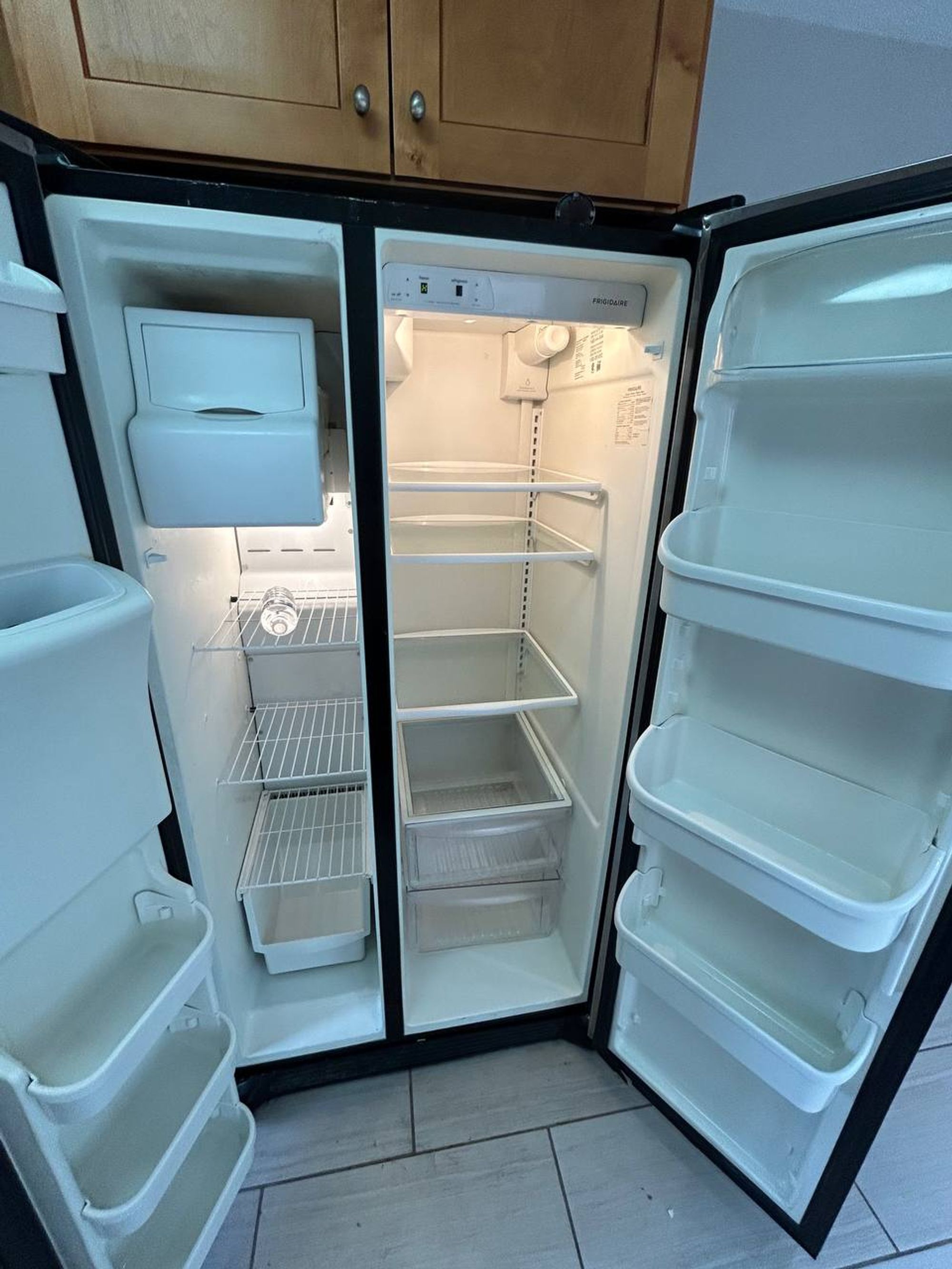 Empty side by side fridge with clean shelves and door bins