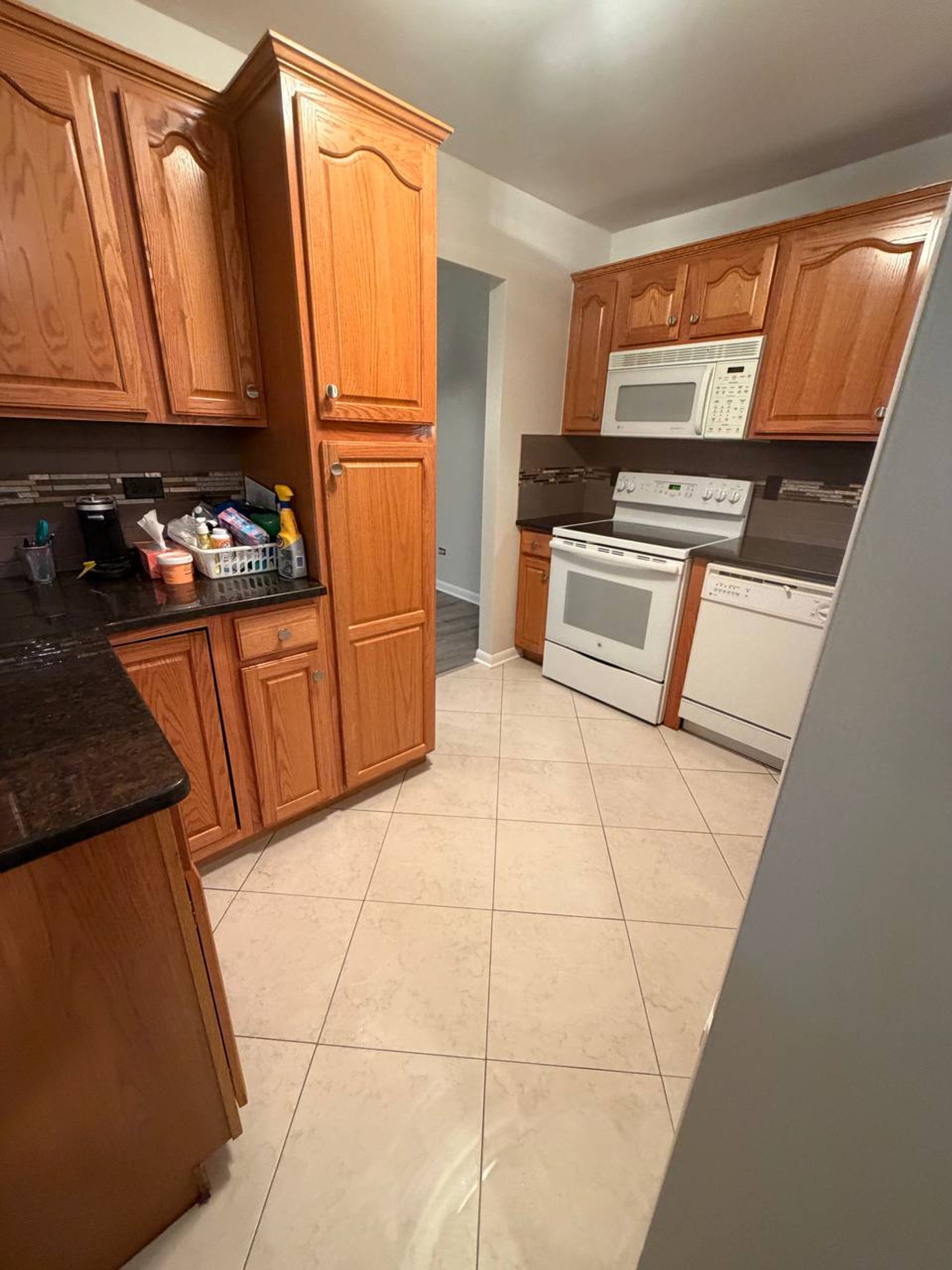 Kitchen with oak cabinets, white range and mopped beige tile floor