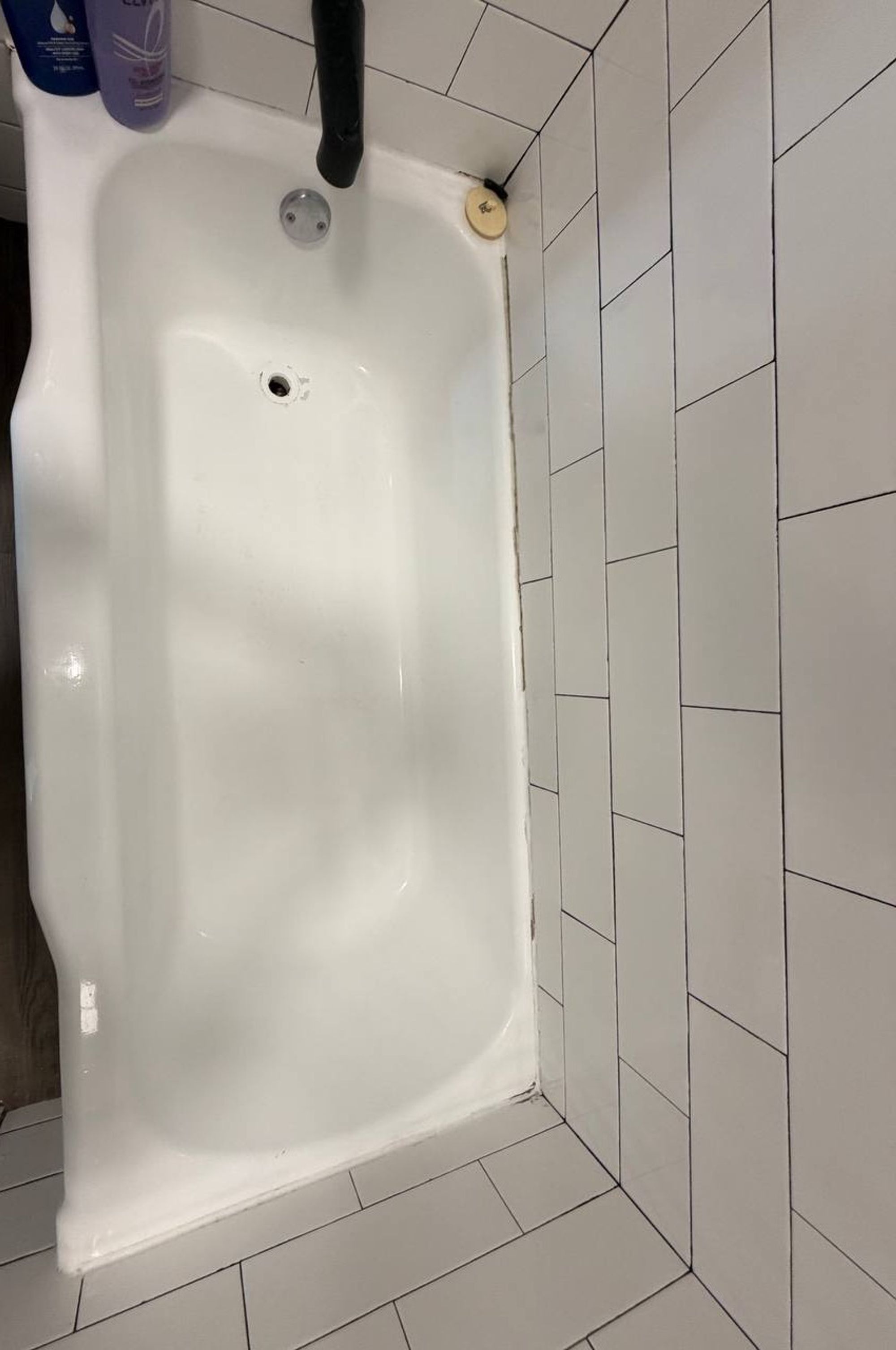 Clean white bathtub against a wall of white subway tile