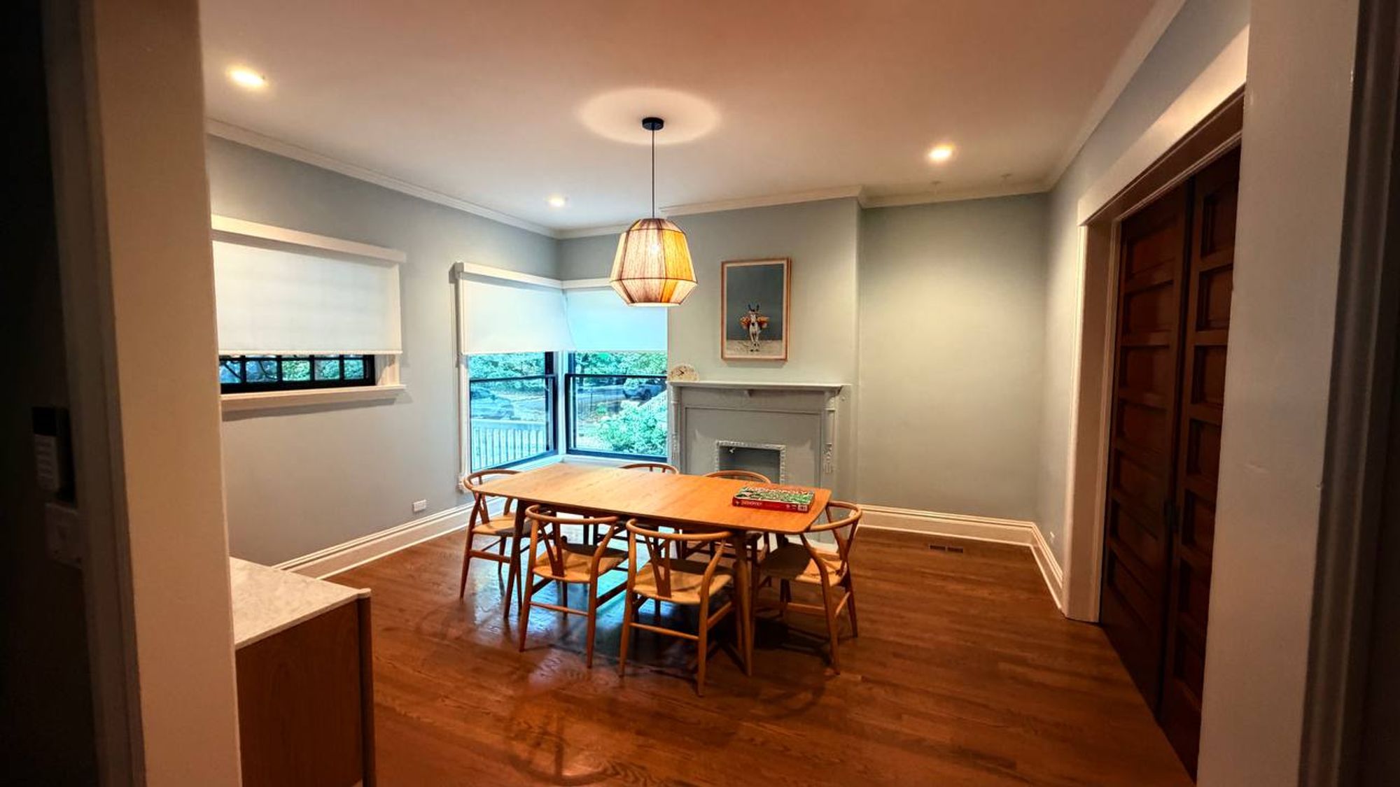Dining room with wood table, pendant light and fireplace mantel