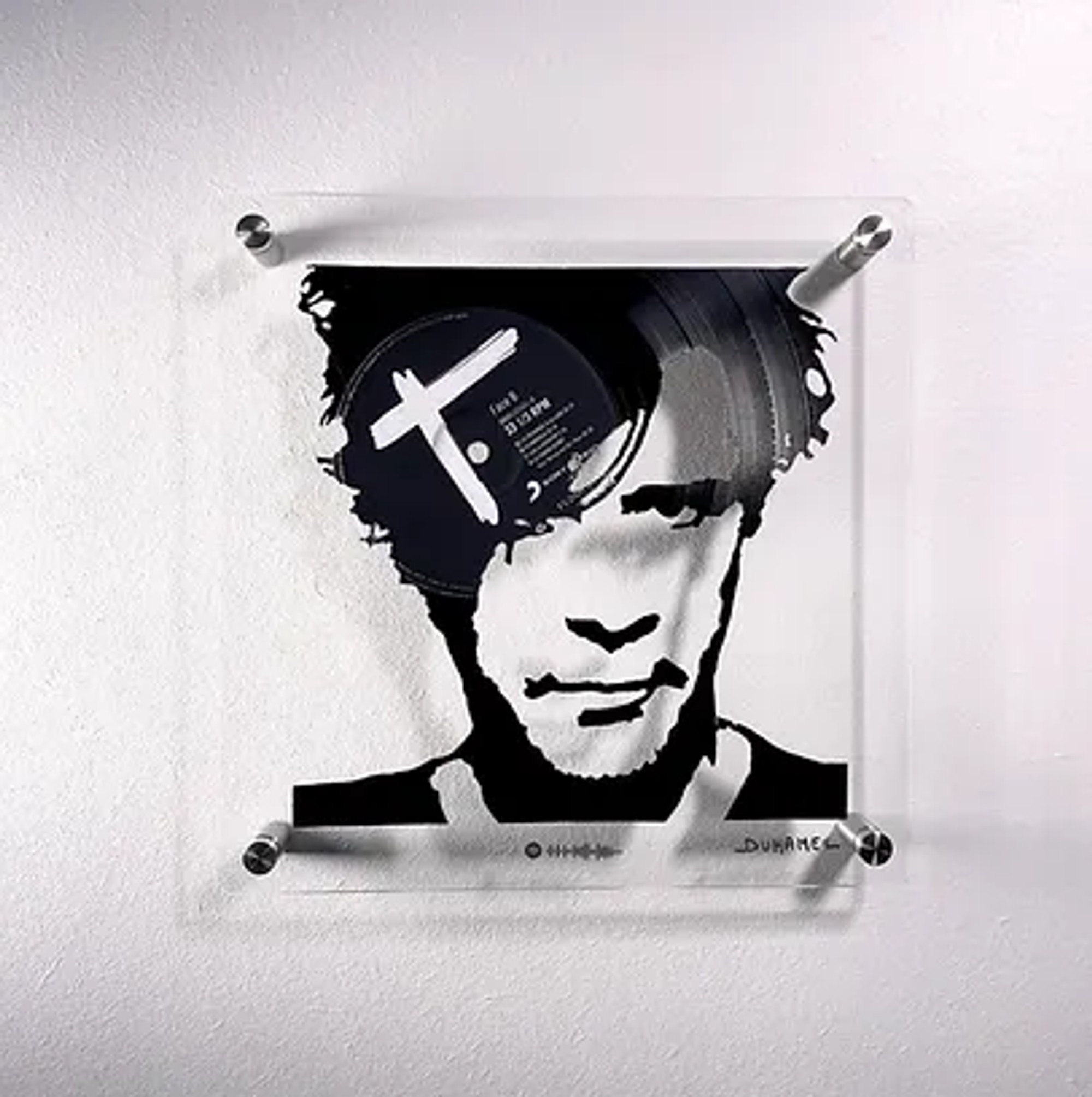 Portrait Nicola Sirkis représentant une composition visuelle et sonore complexe réalisée à partir de disques vinyles.