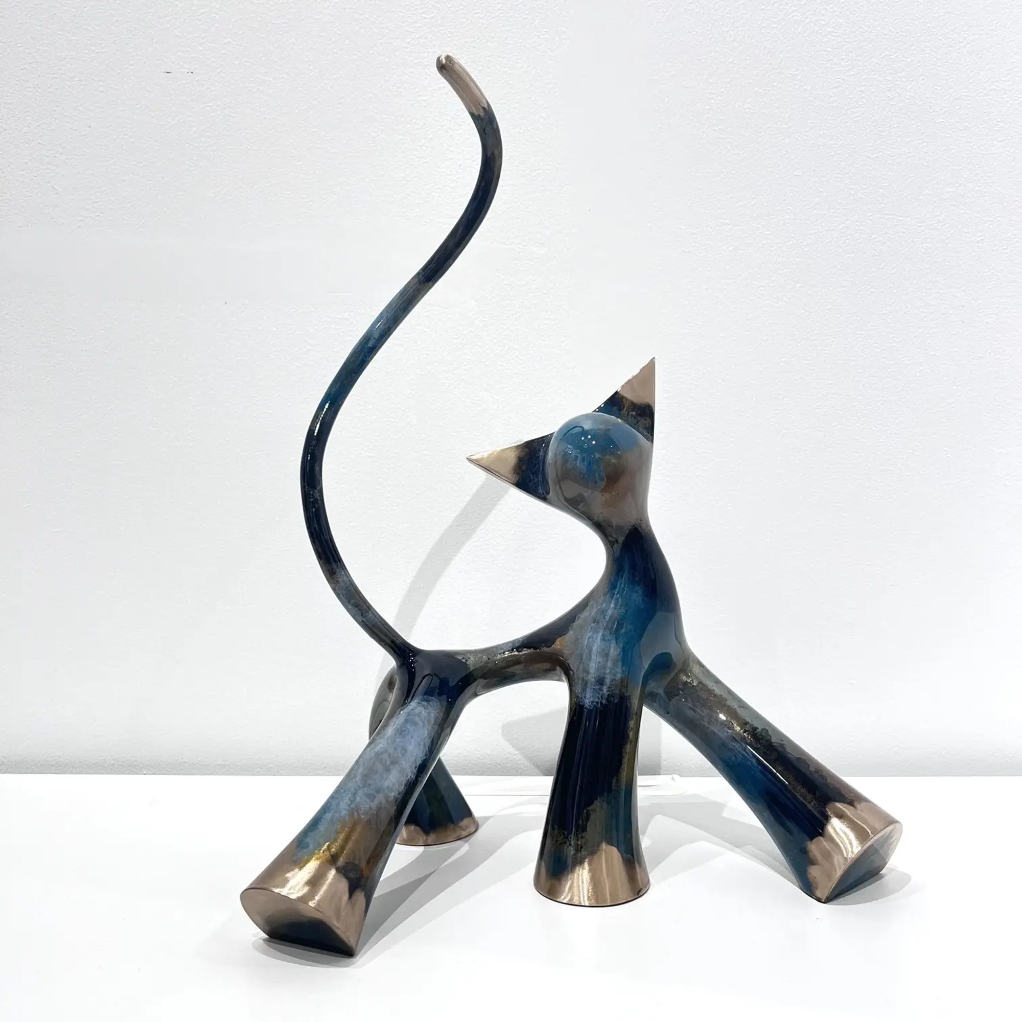 Sculpture ample noir gris cobalt meulé, pattes élargies, contrastes électriques, brillance métallique.