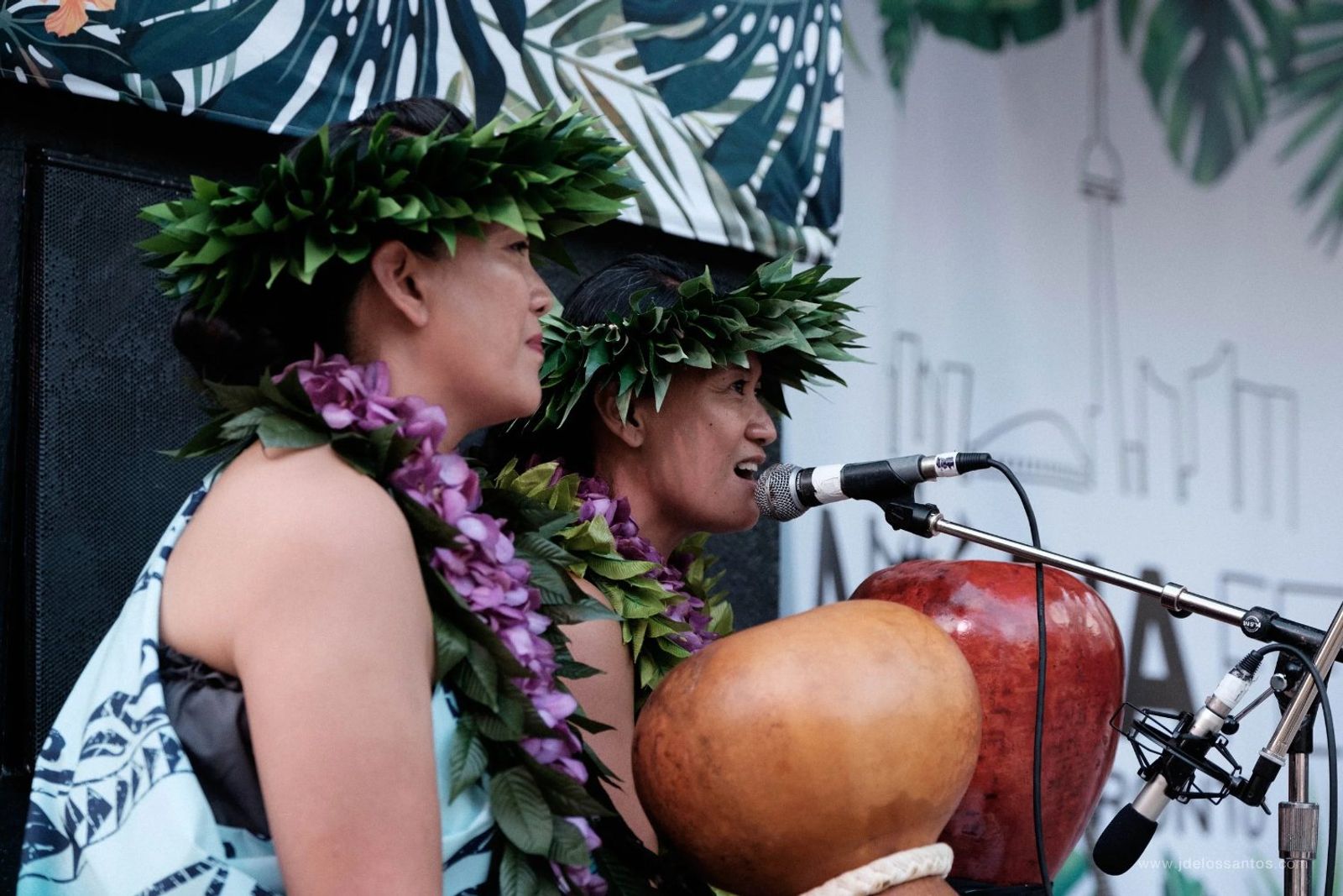 Two hālau chanters with ipu (gourd drum) at a microphone at AlohaFest Toronto
