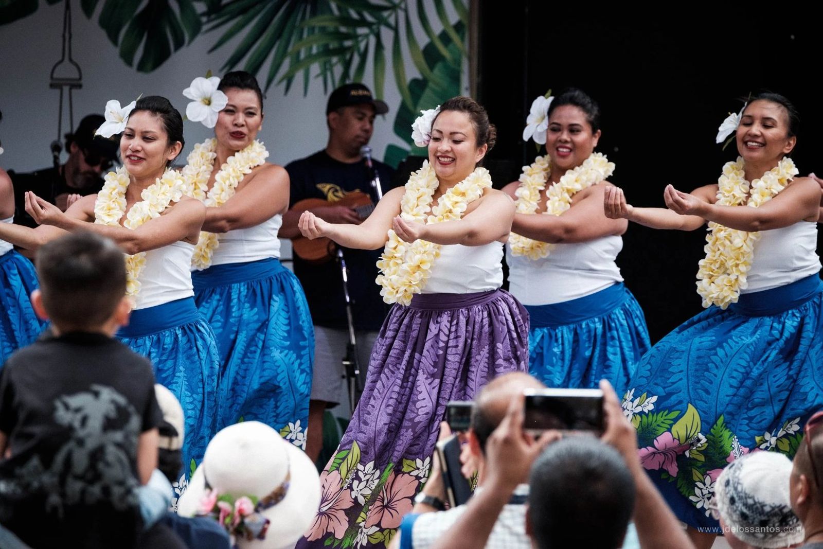 Adult hālau dancers performing together on stage at AlohaFest Toronto