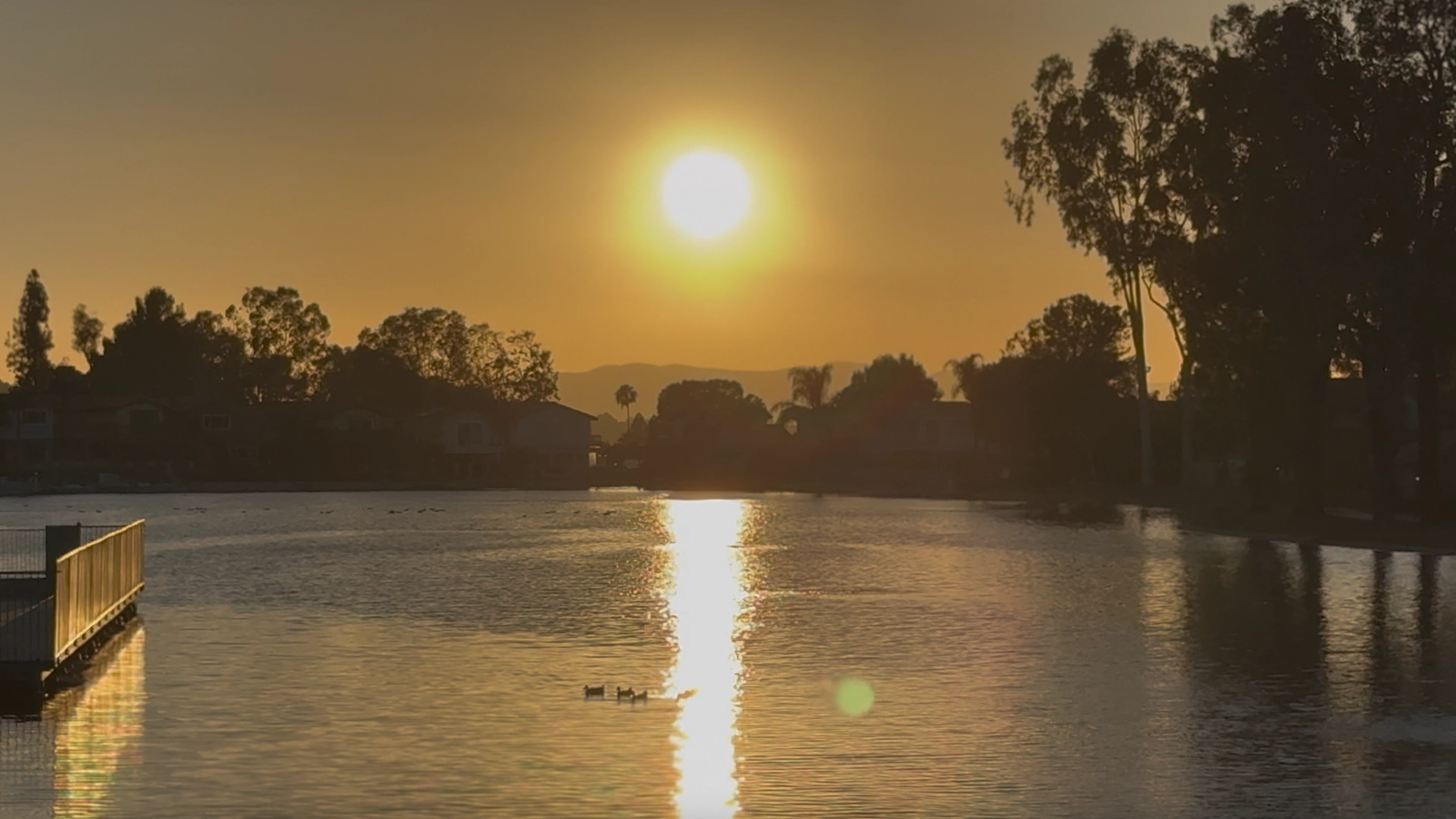 Golden California sunset reflecting across a calm lake.
