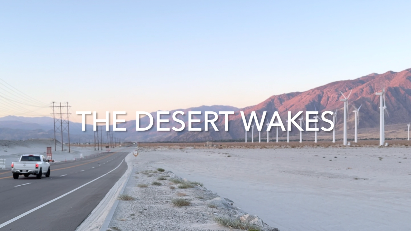 Desert road with wind turbines and mountains near Palm Springs, California.