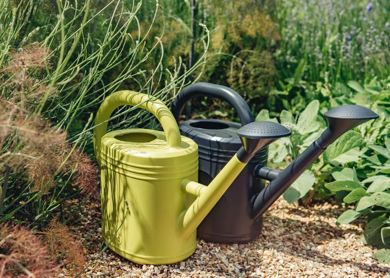 Two recycled plastic watering cans. One in bright green and one in dark green.