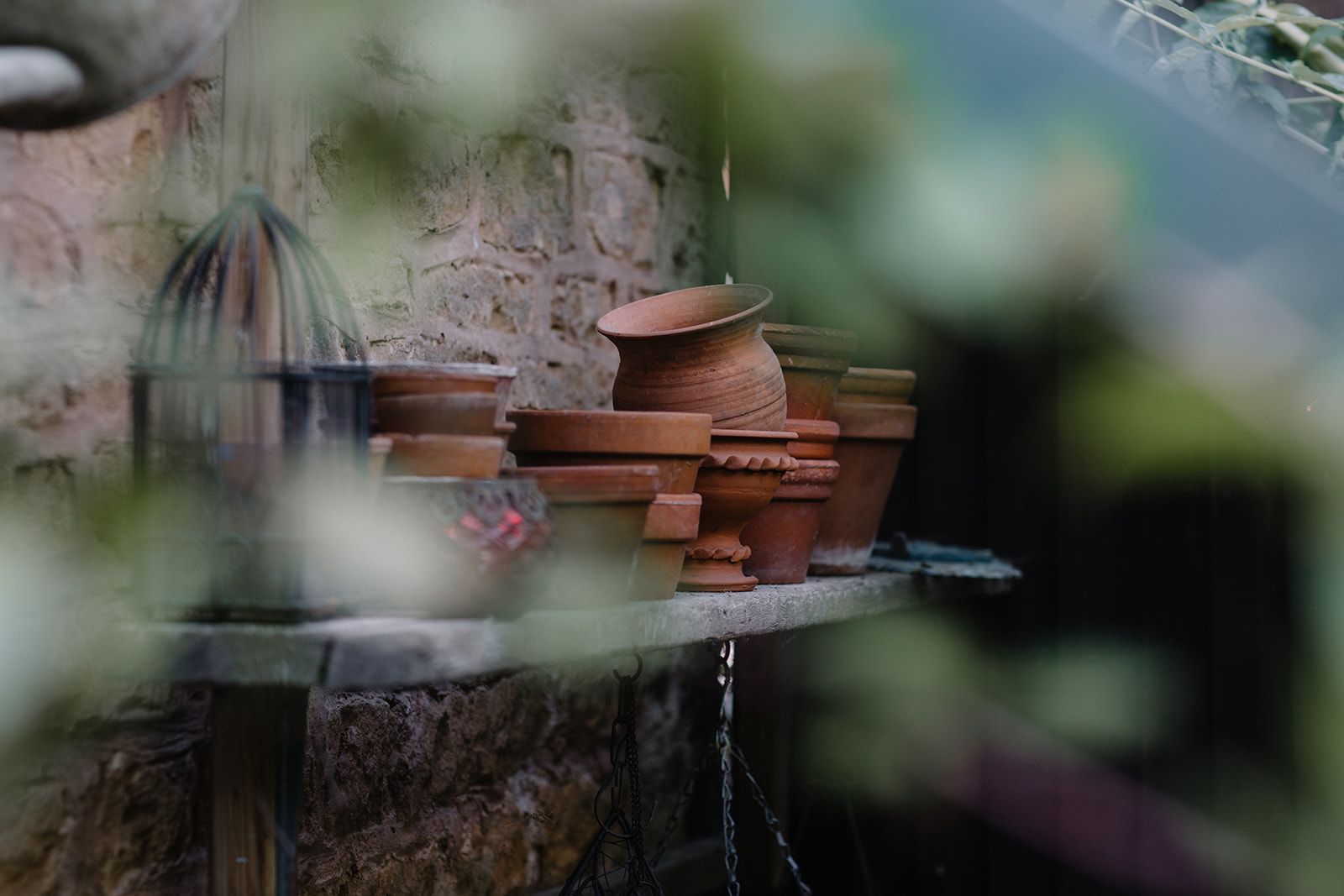 A wooden table stacked with terracotta pots in various shapes and sizes.