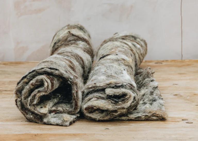 Two rolls of multi-coloured raw wool, made for lining hanging baskets.