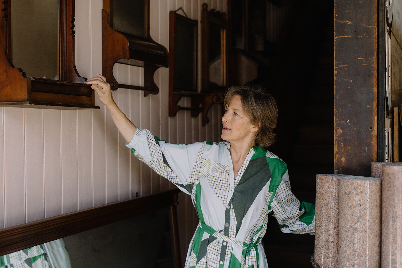 Maria Speake stands at the entrance to the Retrouvius warehouse. She admired an antique mirror on the wall. 