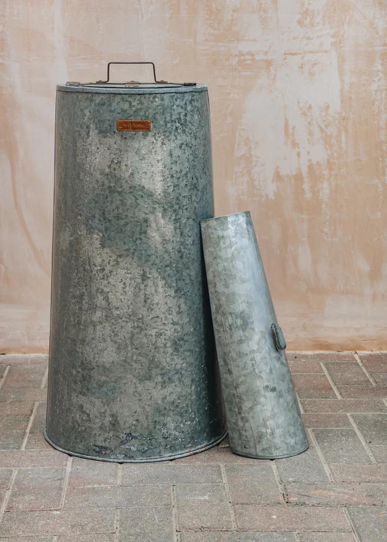 A galvanised steel compost bin with scoop. 