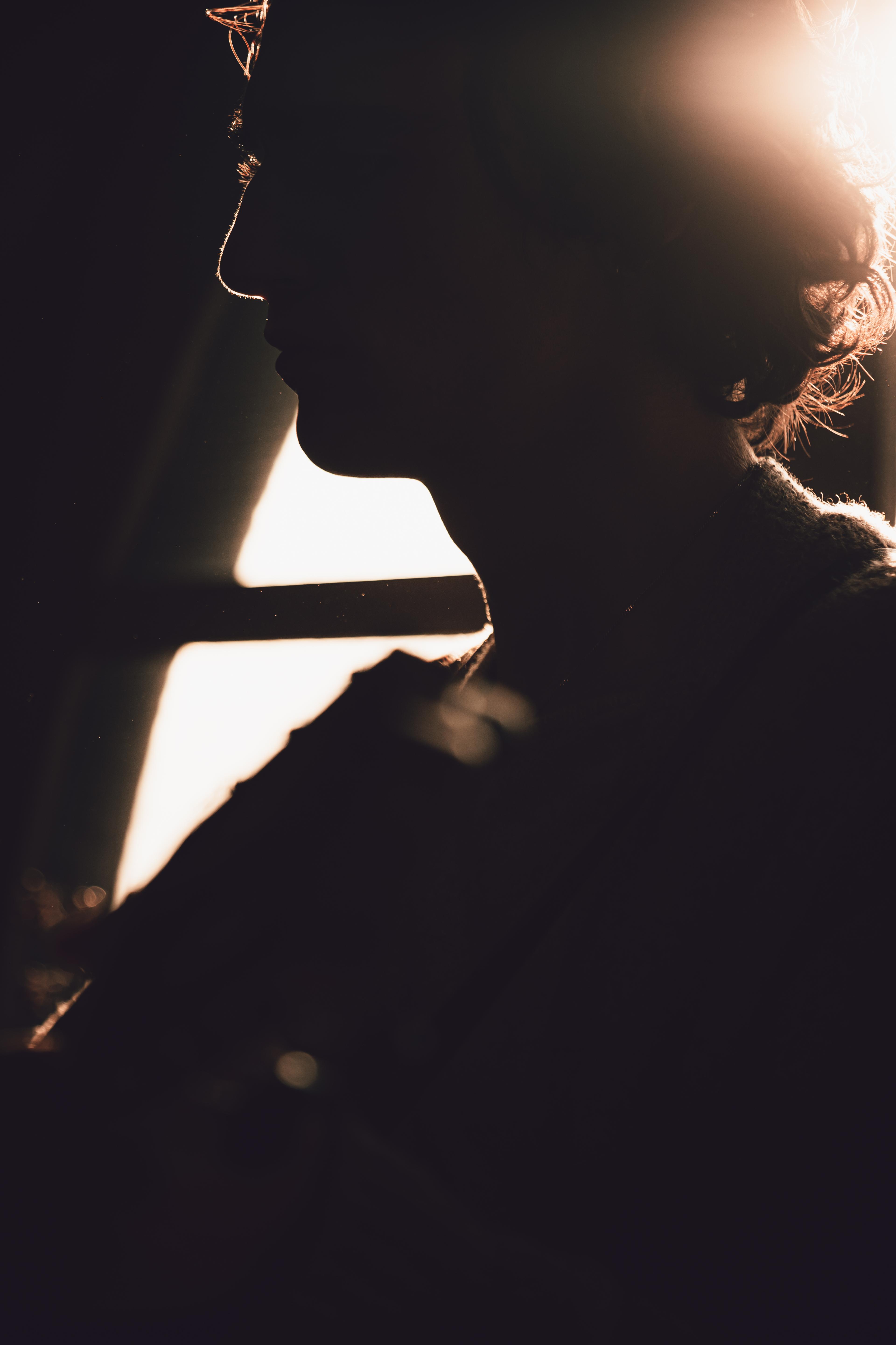 Tamino in a dark room with a faint light showing part of his face.