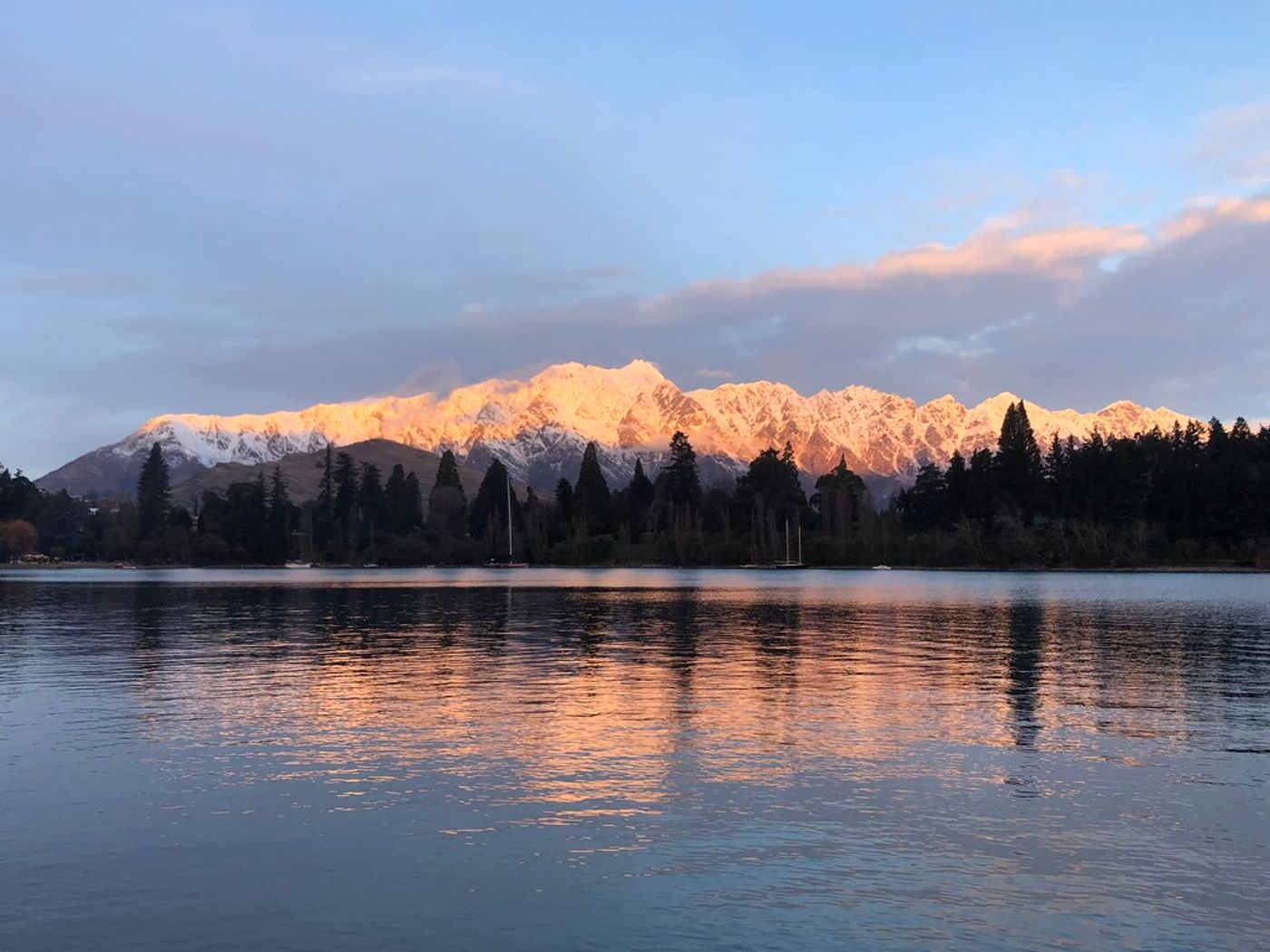 The Remarkables mountain range reflected in Lake Wakatipu at sunset near Queenstown
