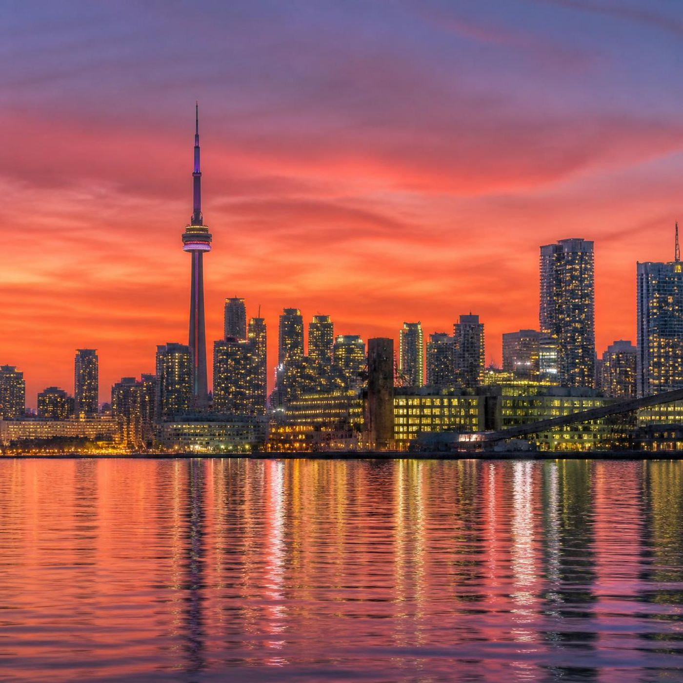 Toronto skyline at sunset with the CN Tower reflected in the harbour water