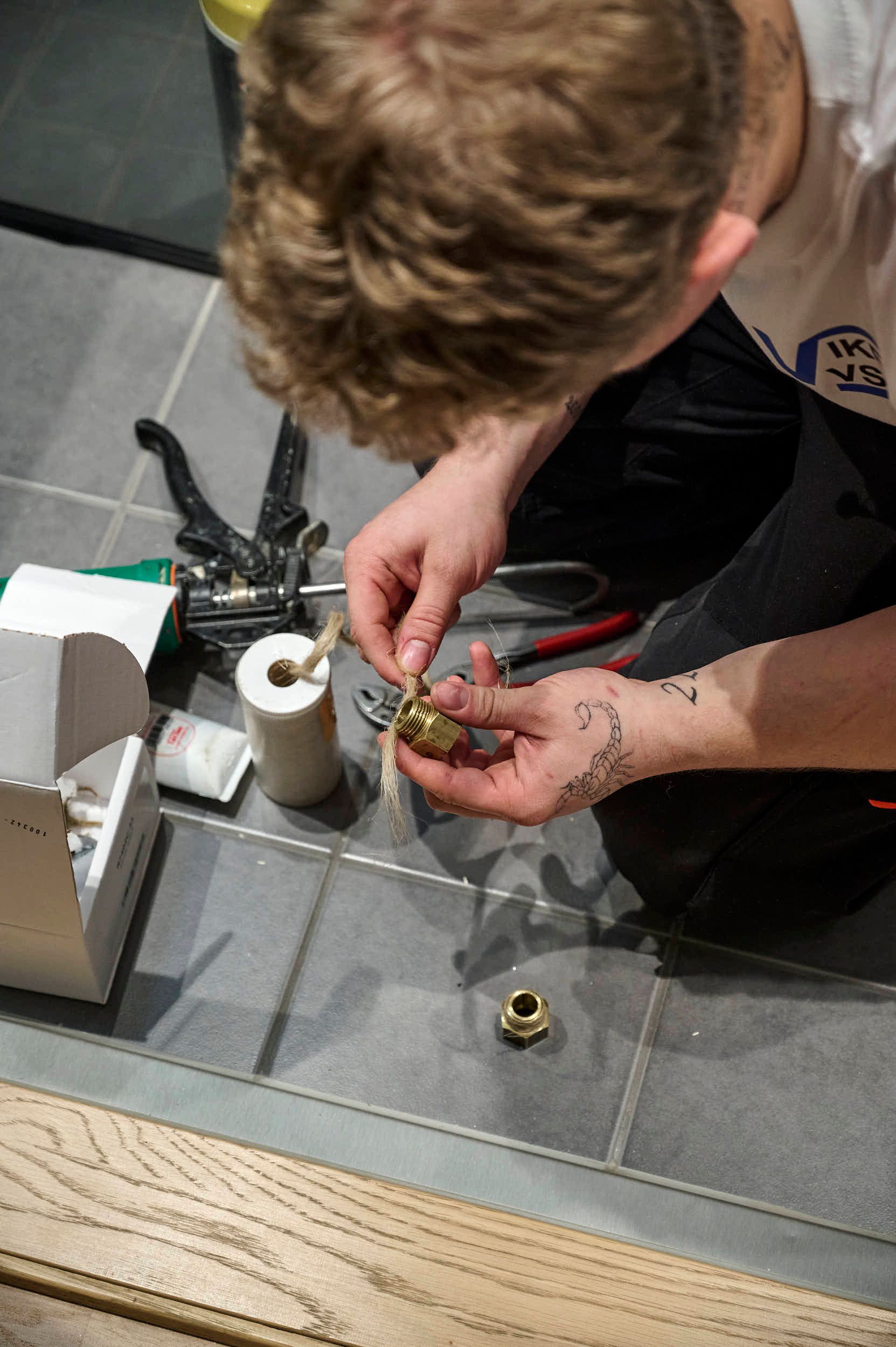 Rørlegger med verktøy jobber