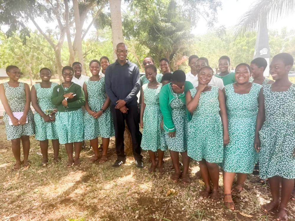 Secondary school students in green uniforms standing with an adult during the Global Learning for Africa research project.
