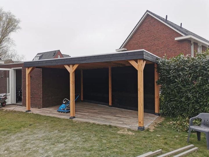 Douglas overkapping met een zwarte achterwand en een tegelvloer in houtlook
