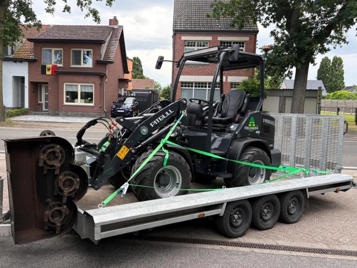 De nieuwe Pitbull-shovel van Hellemons Groen met de snoeizaag ervoor, op de aanhanger