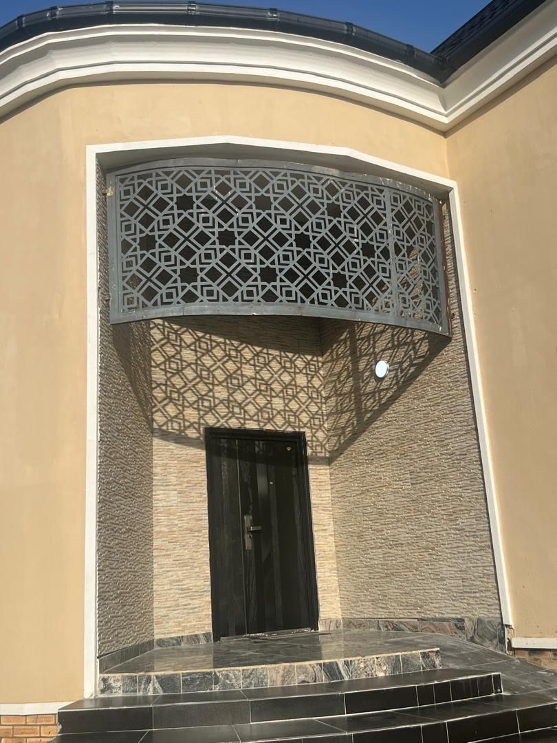 The entrance to the guest house, its metal screen casting a pattern on the wall