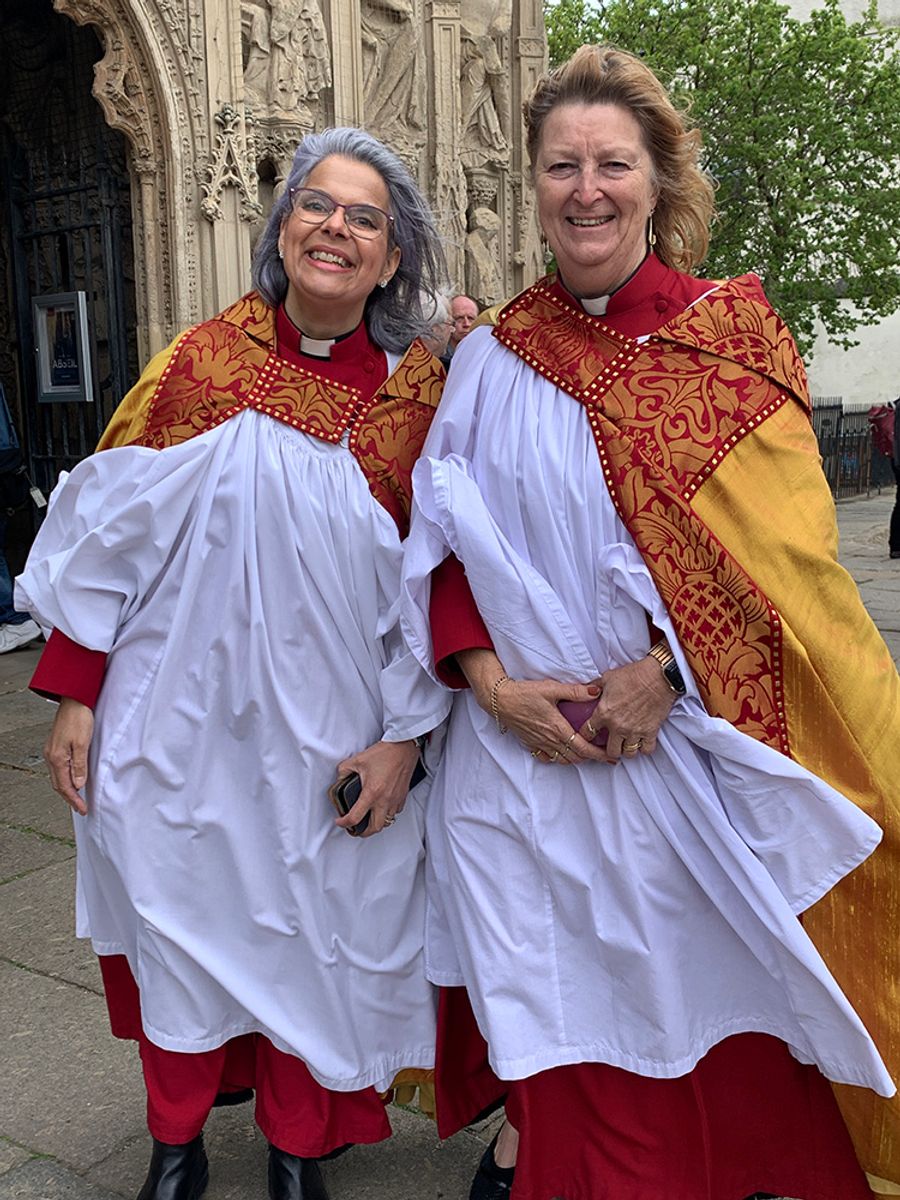 Canon Deborah Parsons and colleagues being blown about in their colourful vestements