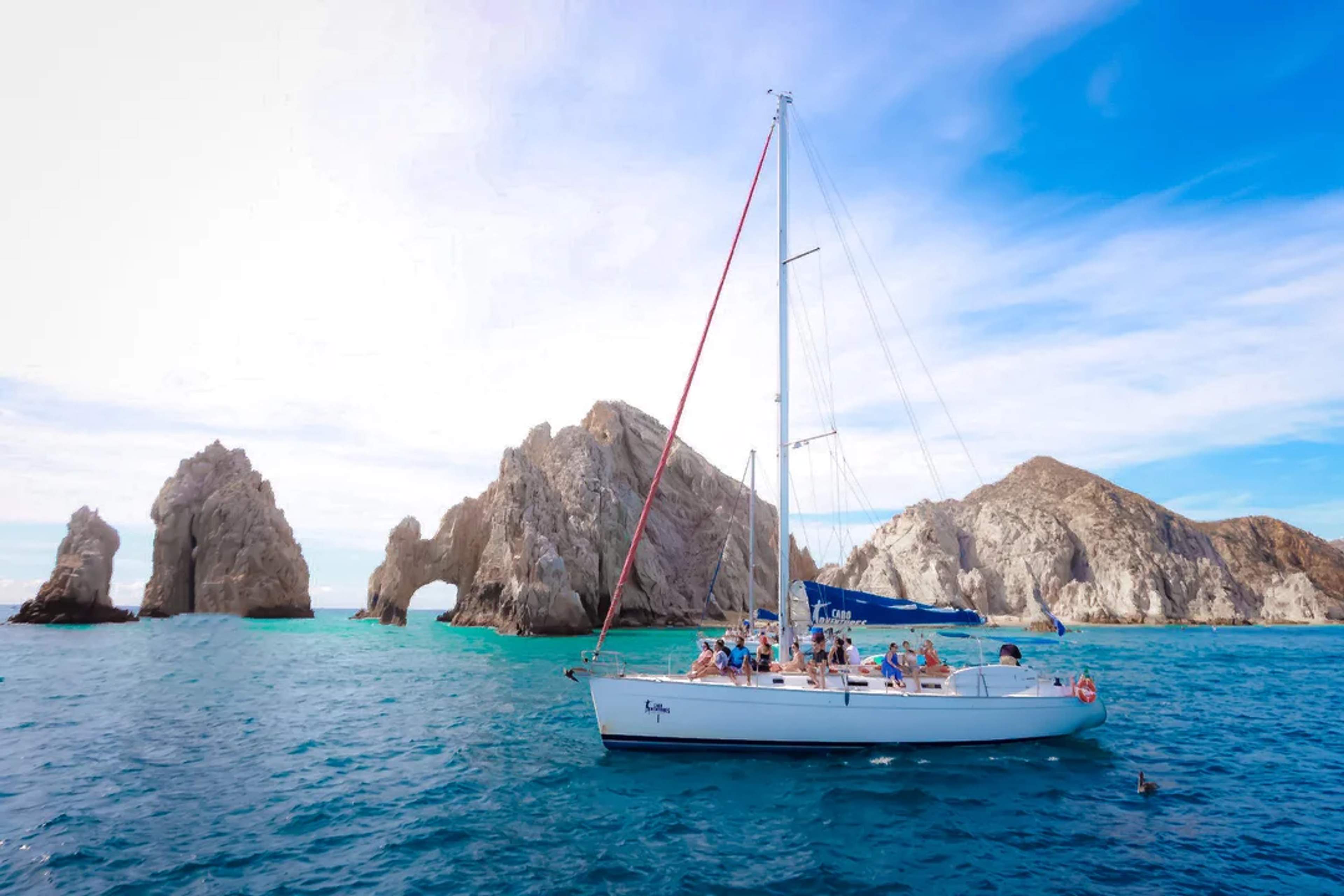 Sailboat with passengers cruises near El Arco in Cabo San Lucas on a bright, sunny day.