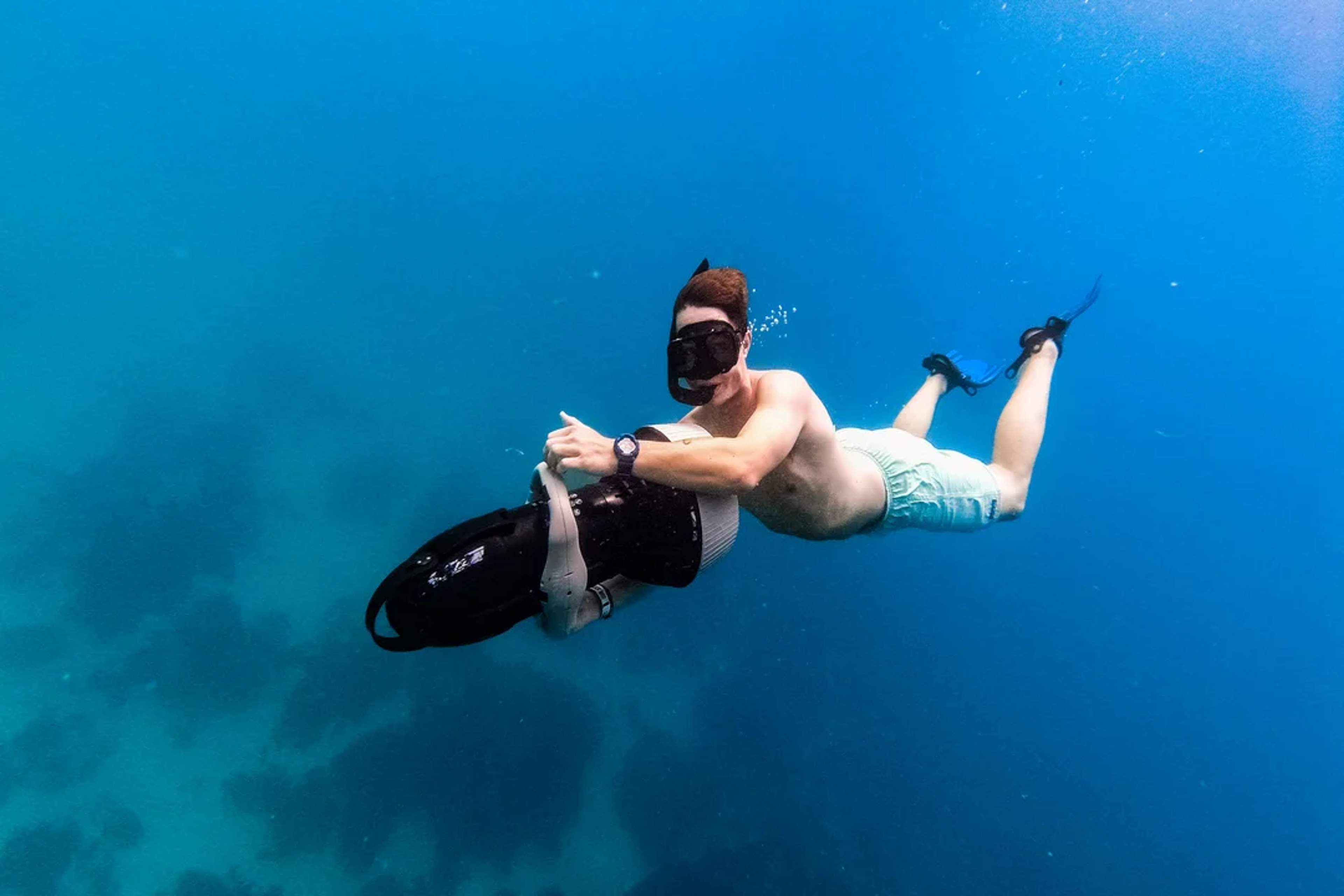 Deslízate bajo el agua con un scooter submarino y explora un mundo marino lleno de vida y color.