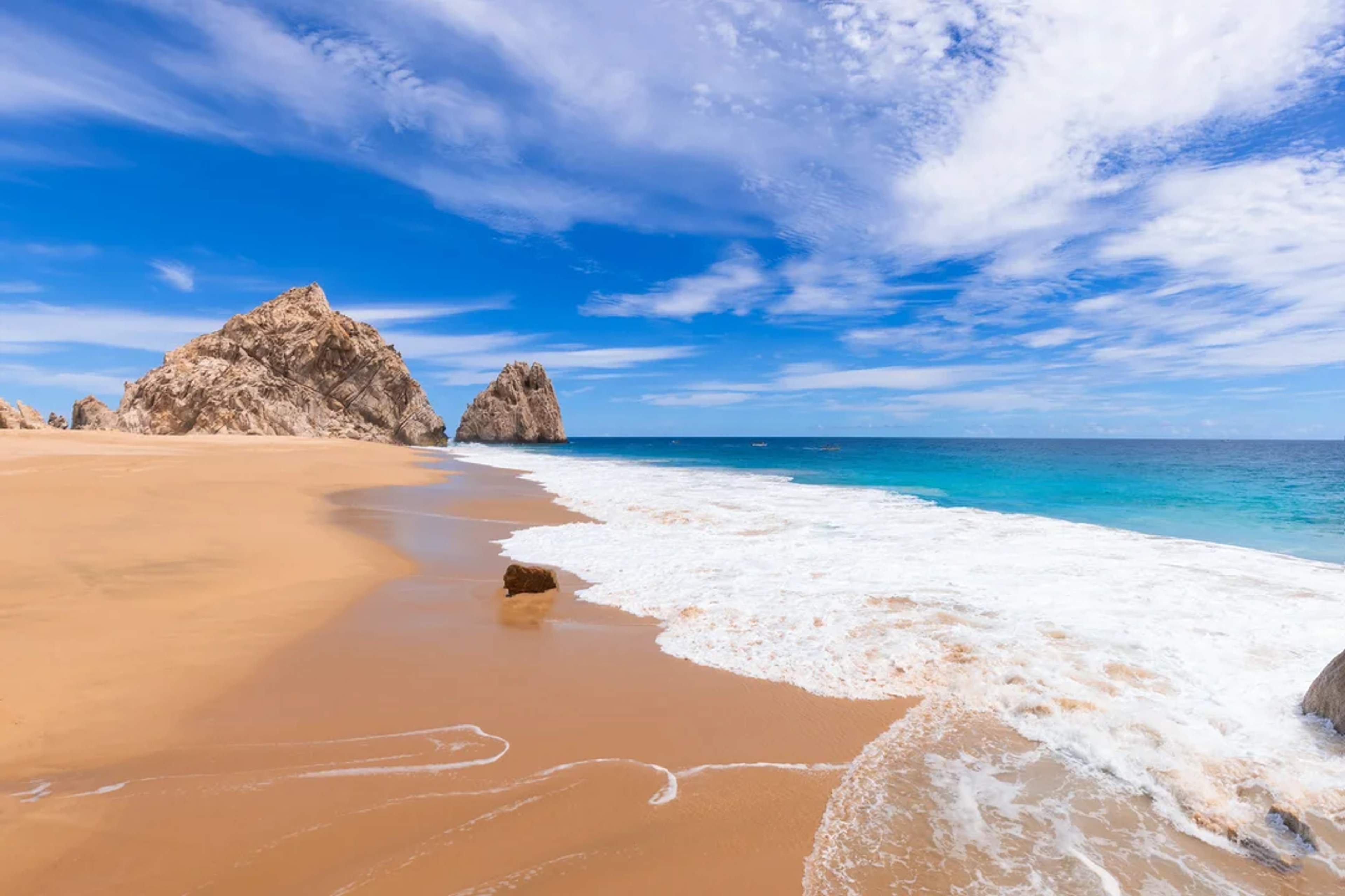 Descubre Playa del Amor en Cabo—arena dorada, olas turquesa y formaciones rocosas asombrosas.