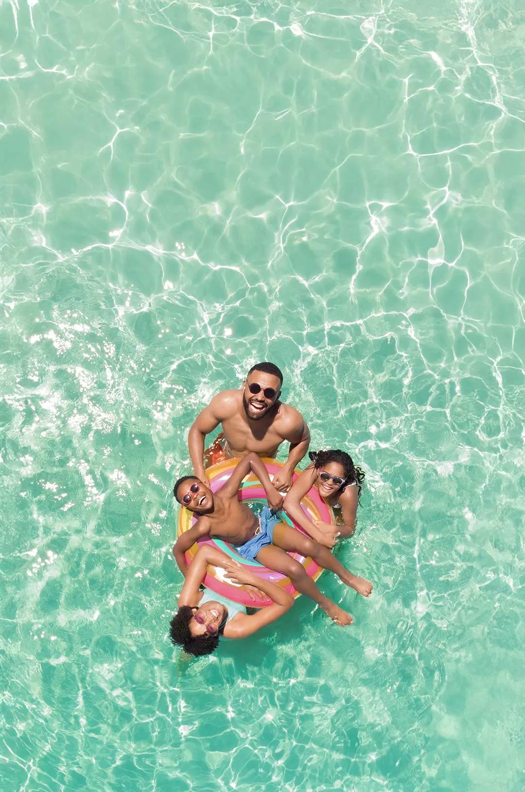Happy family enjoying pool day on a float at Tierra Sagrada Beach & Adventure Park in Cabo