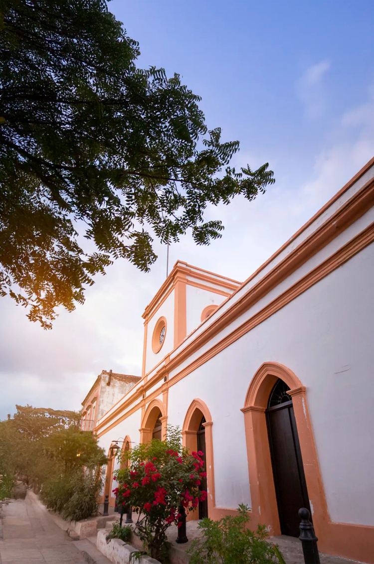 Fachada de iglesia histórica en El Triunfo, Baja California Sur, con arquitectura colonial, arcos y encanto local.