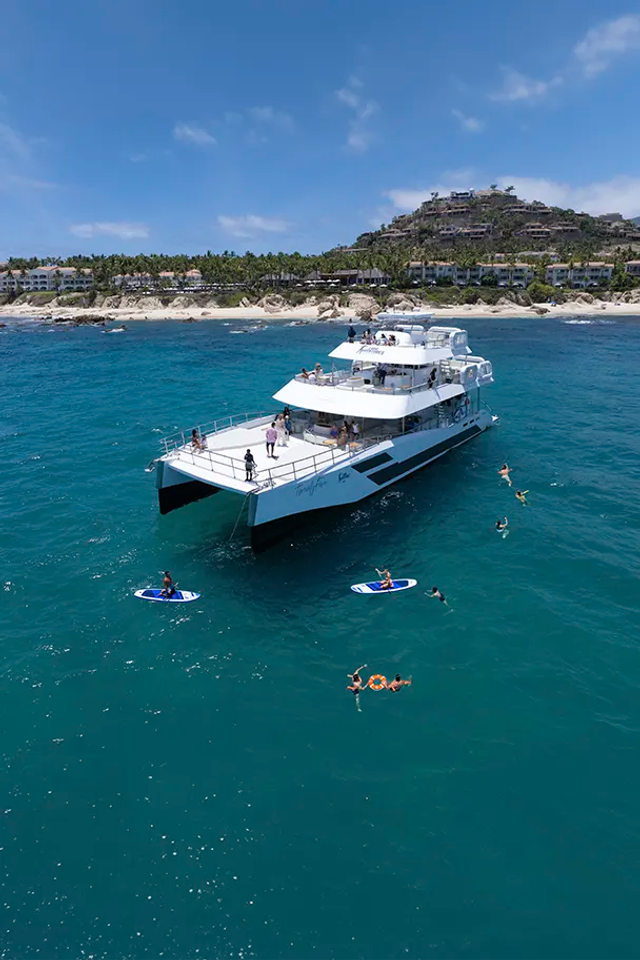 TwentyFive premium 100-ft catamaran sailing in Cabo San Lucas, triple-deck design, open sea views and luxury day cruise.