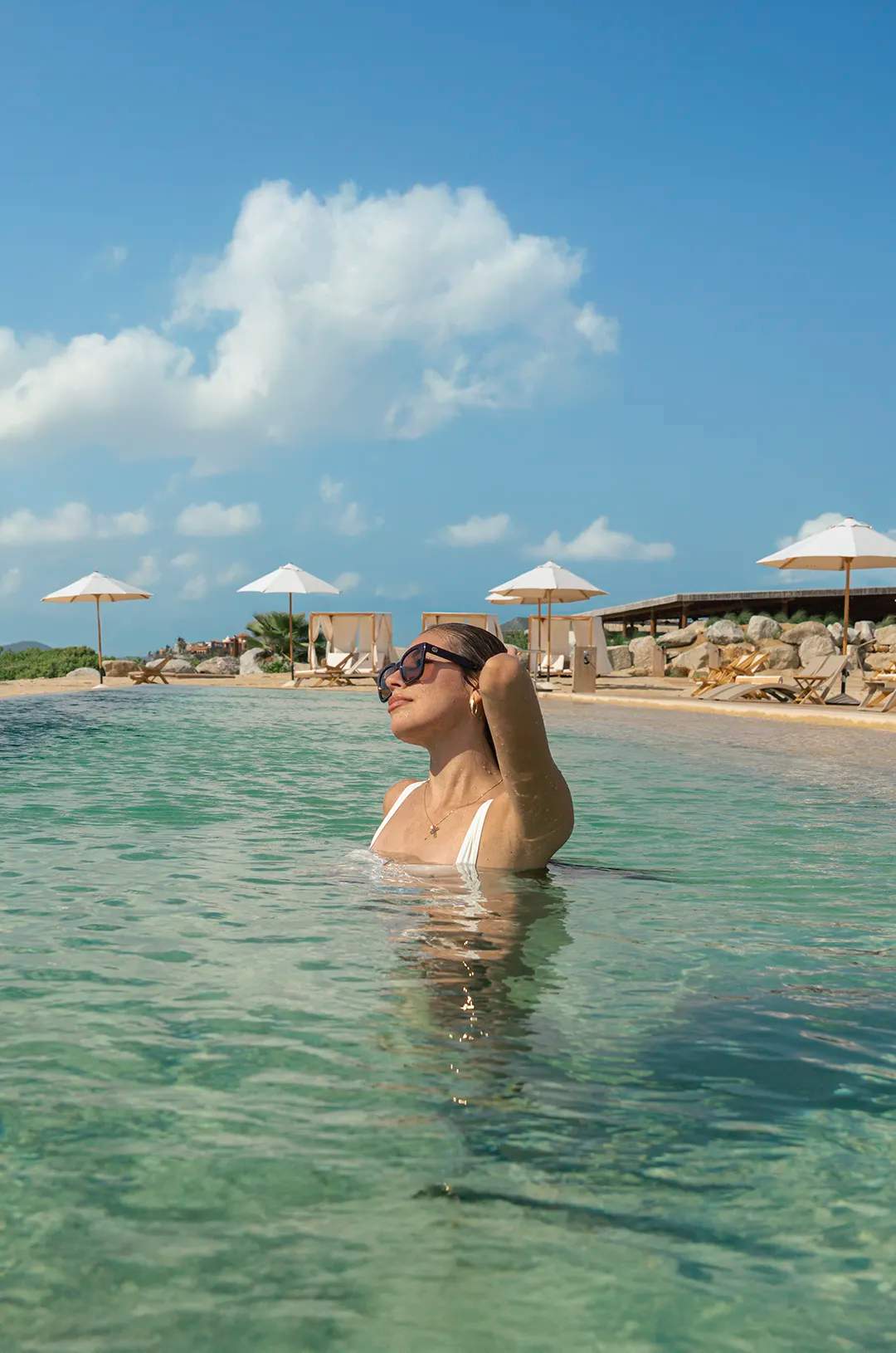Woman enjoying the pool at Tierra Sagrada Beach Club, Los Cabos, Mexico.