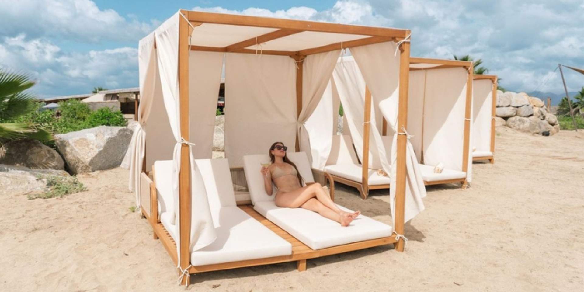 Guest relaxing in luxury beach cabana at Tierra Sagrada Beach Club in Cabo San Lucas