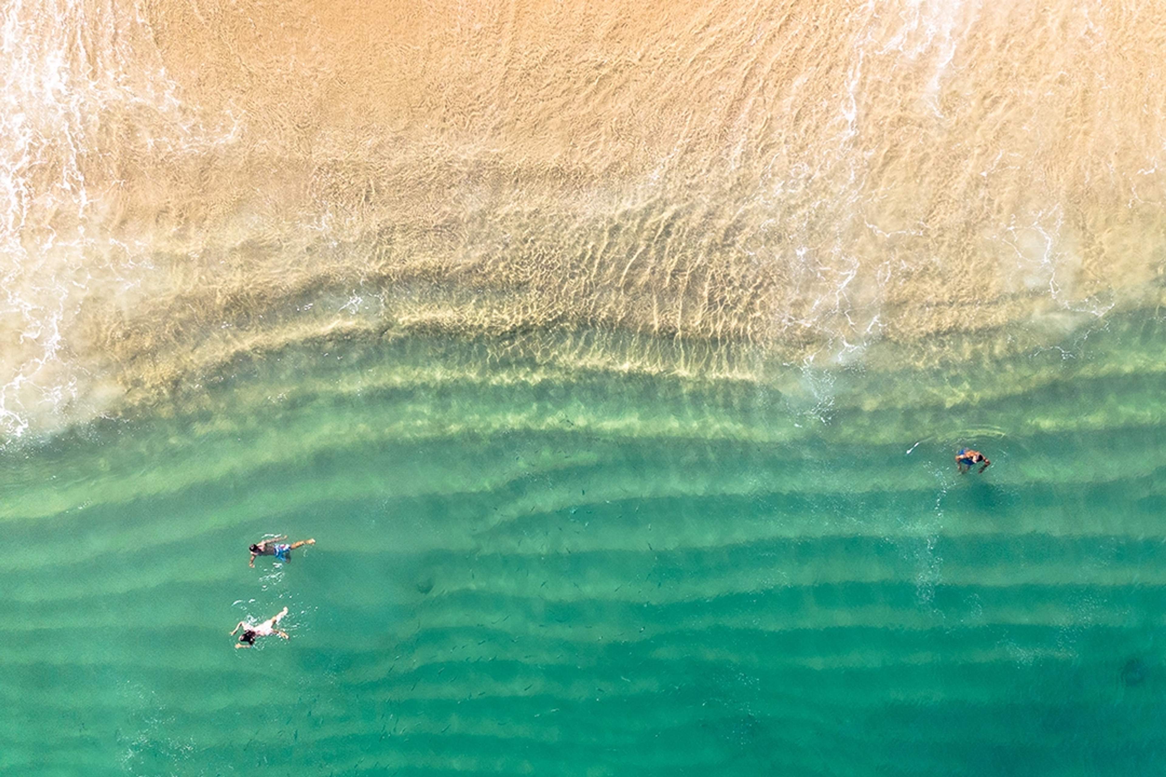 Una hermosa bahía con arena dorada, aguas turquesas y barcos anclados en Cabo San Lucas, ideal para nadar y relajarse.