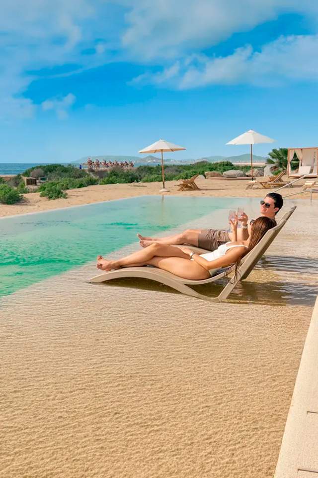 Woman enjoying the pool at Tierra Sagrada Beach Club, Los Cabos, Mexico.