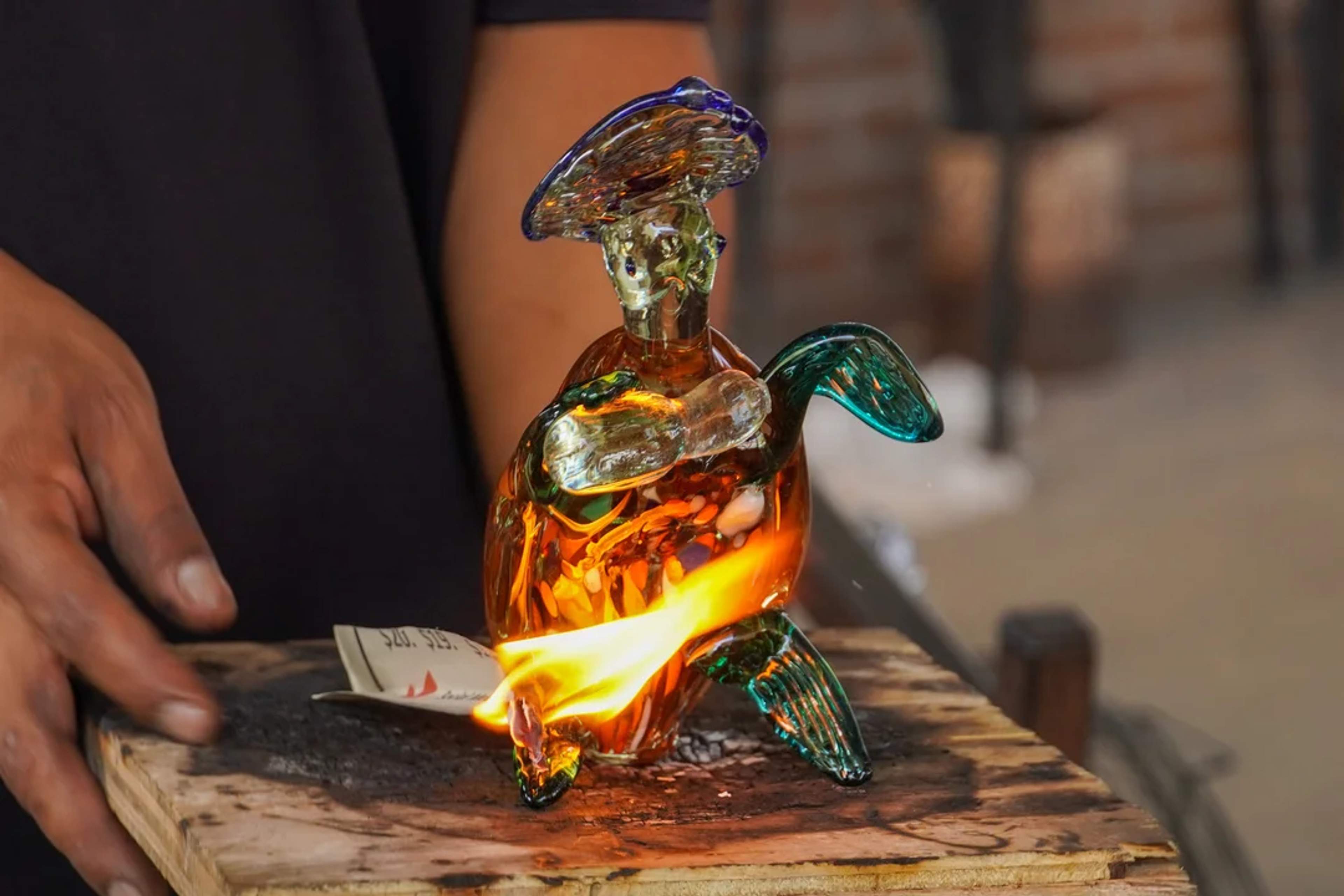 Una colorida escultura de tortuga de vidrio se crea con fuego en una demostración en vivo.