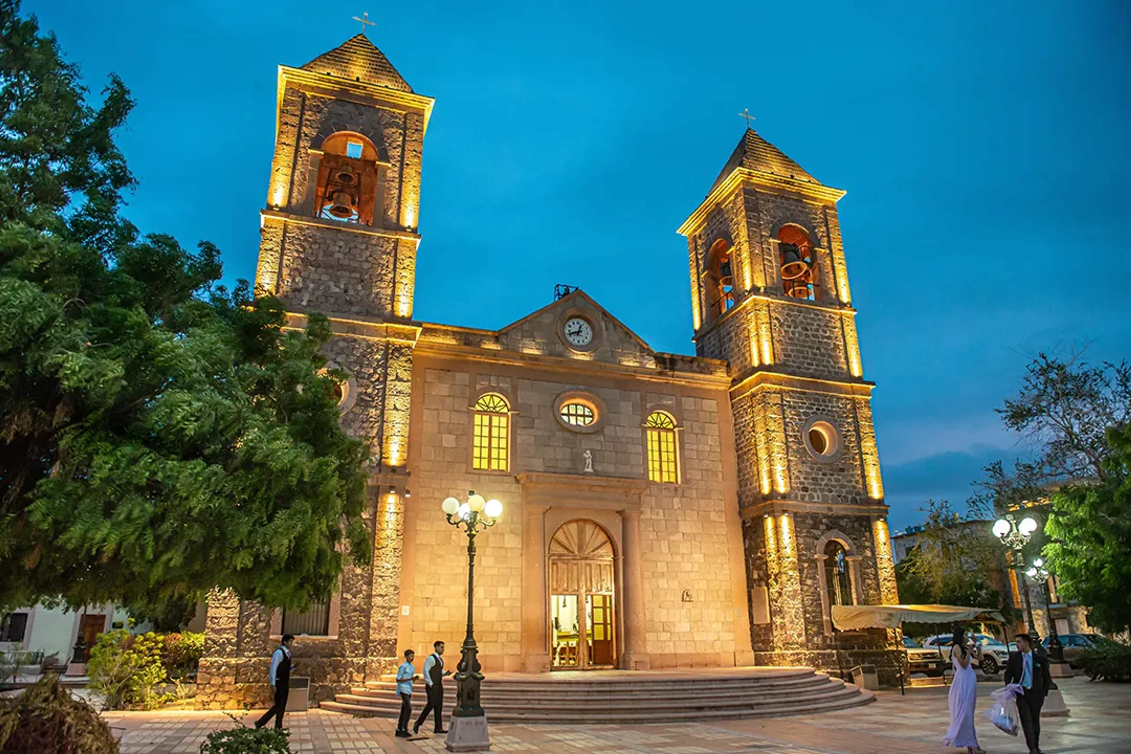 La Paz Cathedral illuminated at dusk, showcasing its historic architecture and peaceful plaza setting