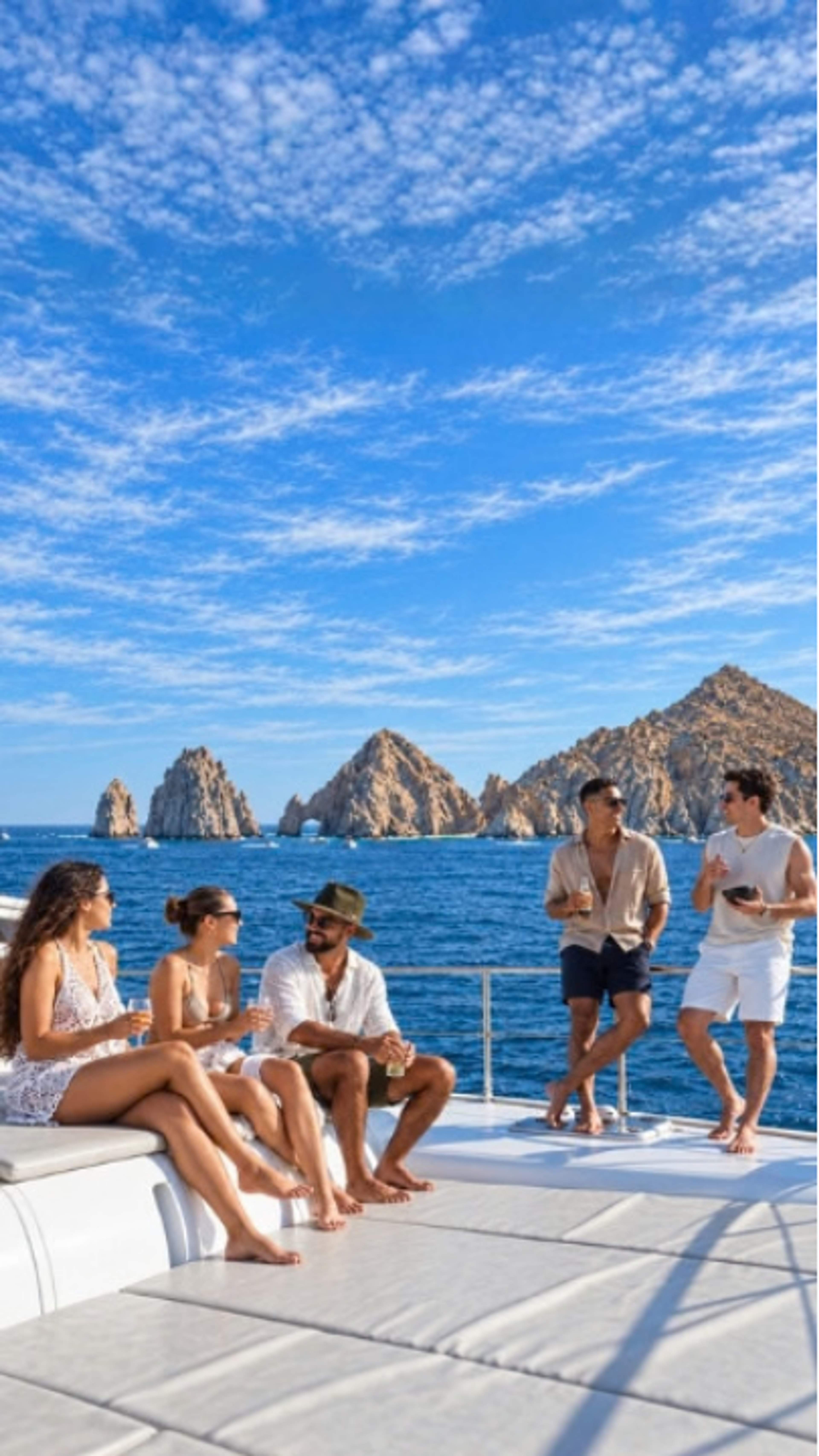 Adult friends relax aboard a Cabo Adventures yacht near Land’s End in Cabo San Lucas.