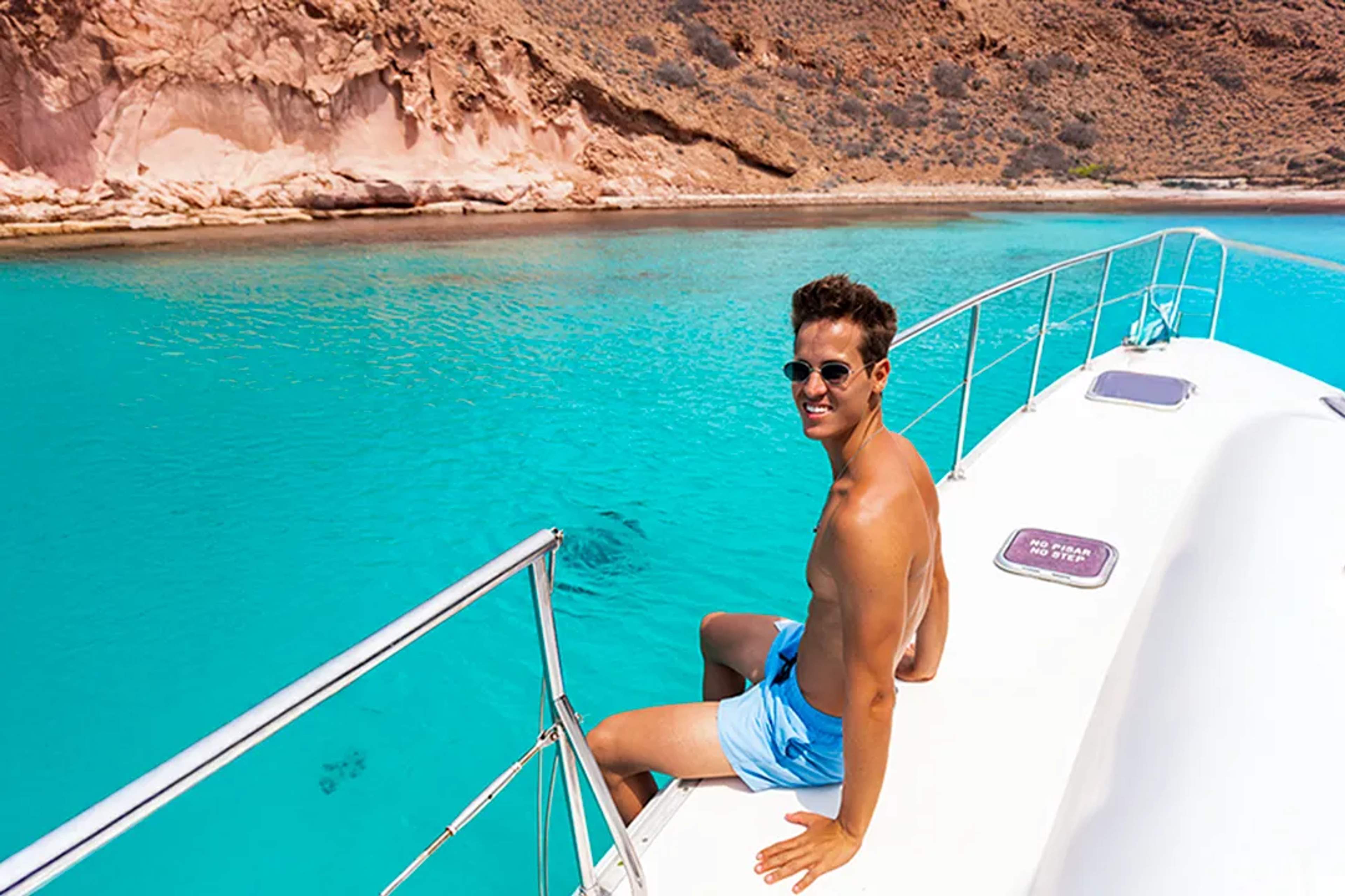 Guest relaxing on a boat in the turquoise waters of Balandra Bay during a scenic tour in La Paz, Baja California.