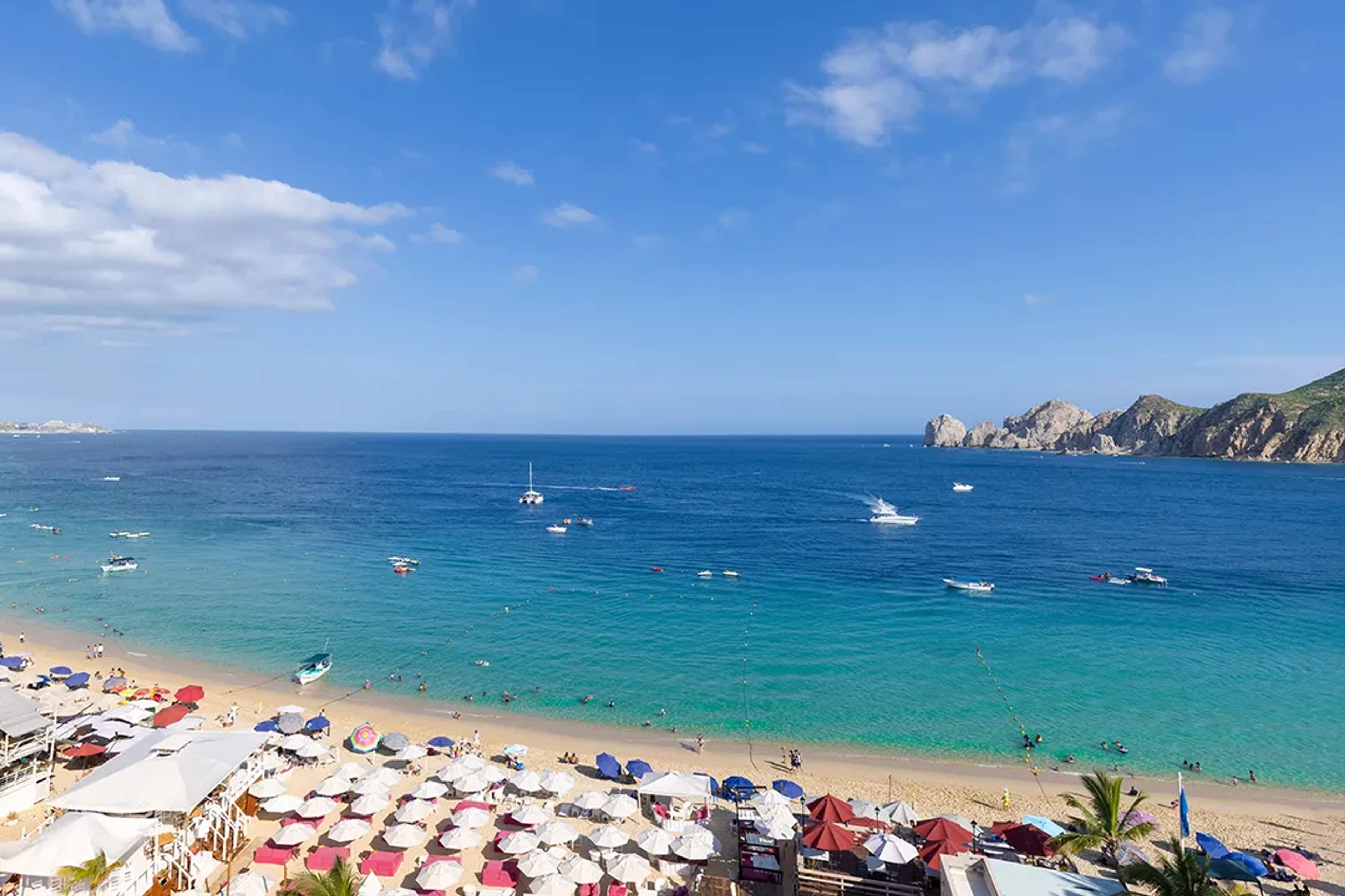 Panoramic view of Los Cabos coastline with calm turquoise waters, perfect weather for ocean tours and beach days