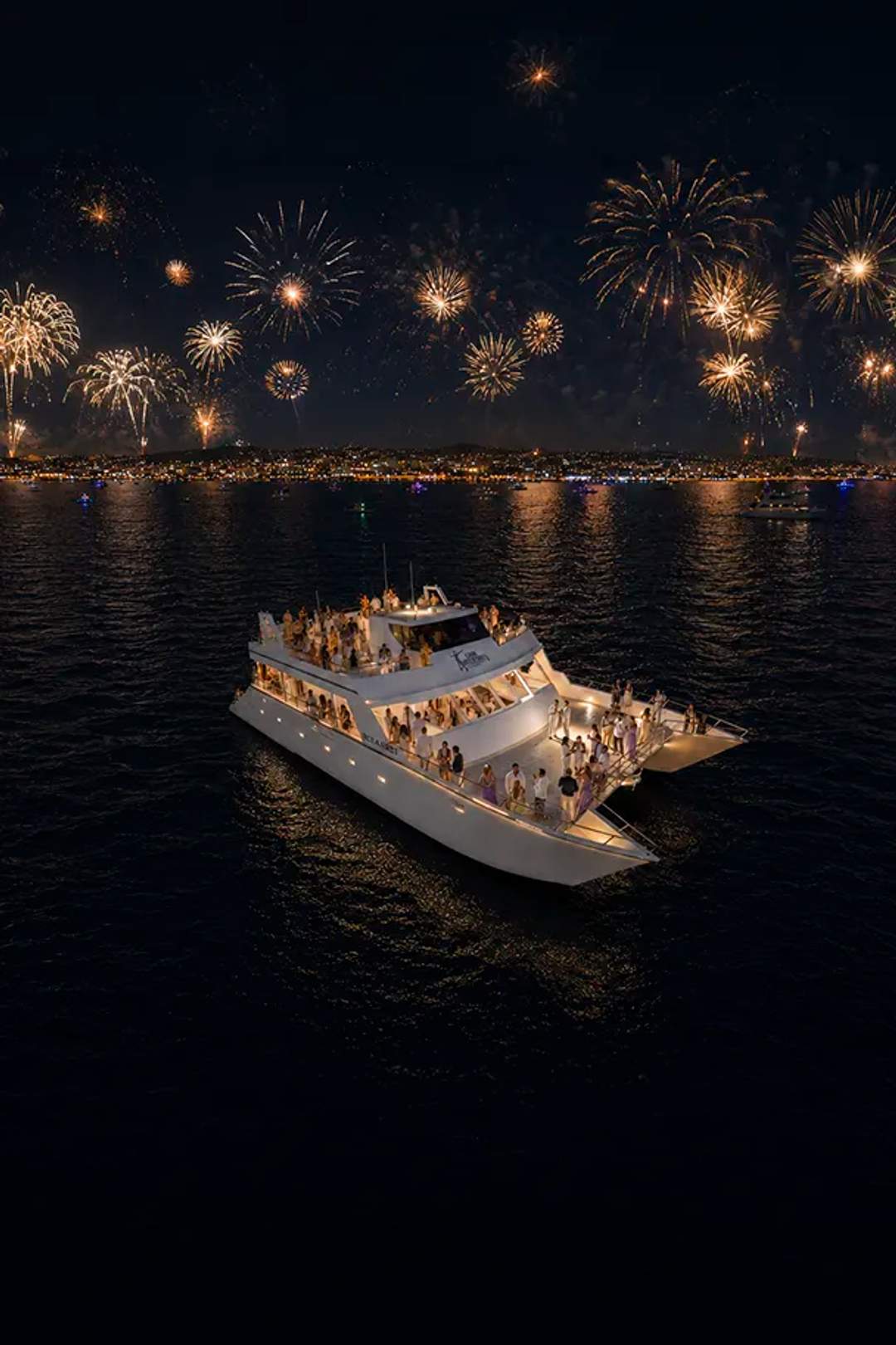 Oceanus catamaran by Cabo Adventures hosts a New Year’s Eve party beneath fireworks over Cabo.