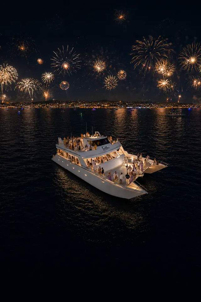 Oceanus catamaran by Cabo Adventures hosts a New Year’s Eve party beneath fireworks over Cabo.