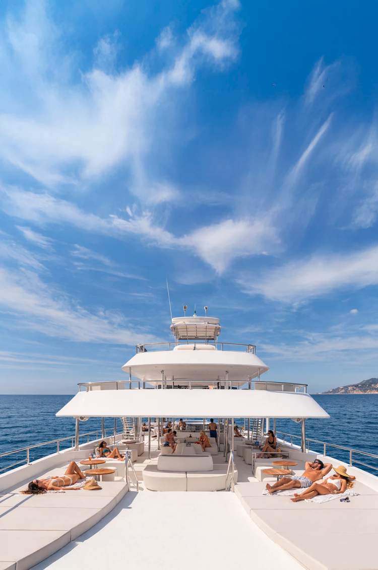 Guests relaxing on the spacious decks of the TwentyFive luxury catamaran during a scenic snorkel cruise in Cabo.
