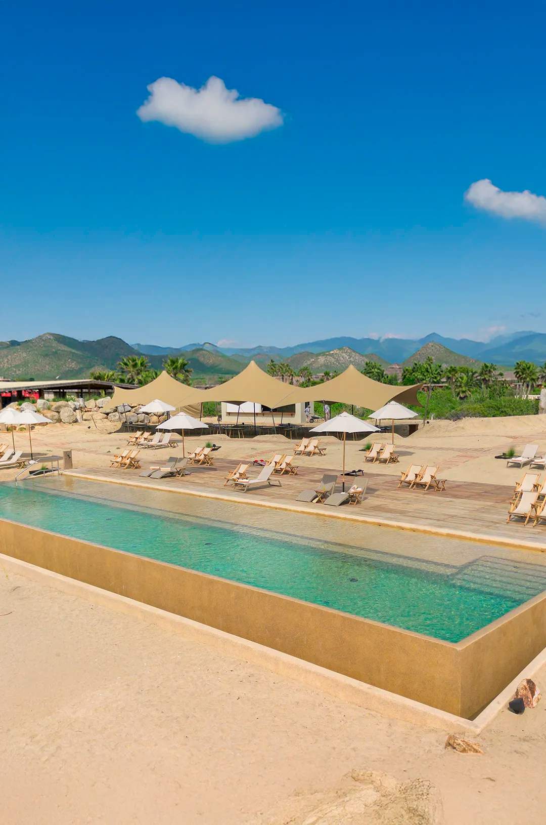 Panoramic view of pool and sun loungers at Tierra Sagrada Beach Club, Los Cabos, Mexico.