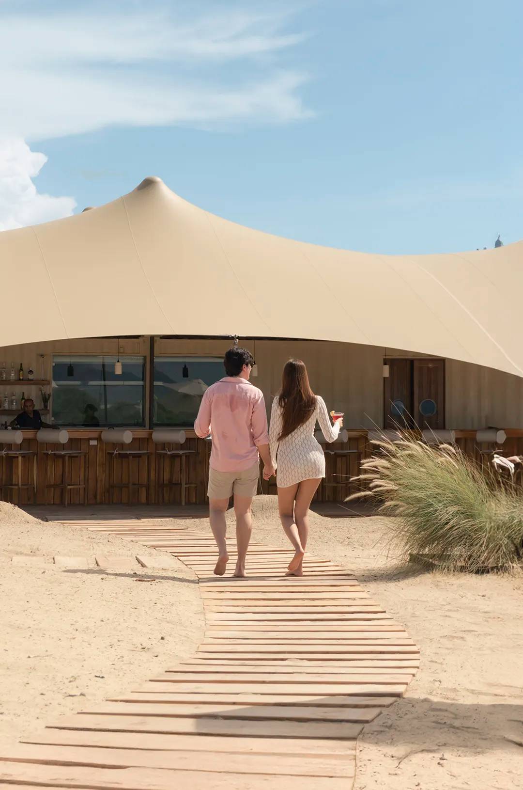Couple walking to the bar at Tierra Sagrada Beach Club, Los Cabos, Mexico.