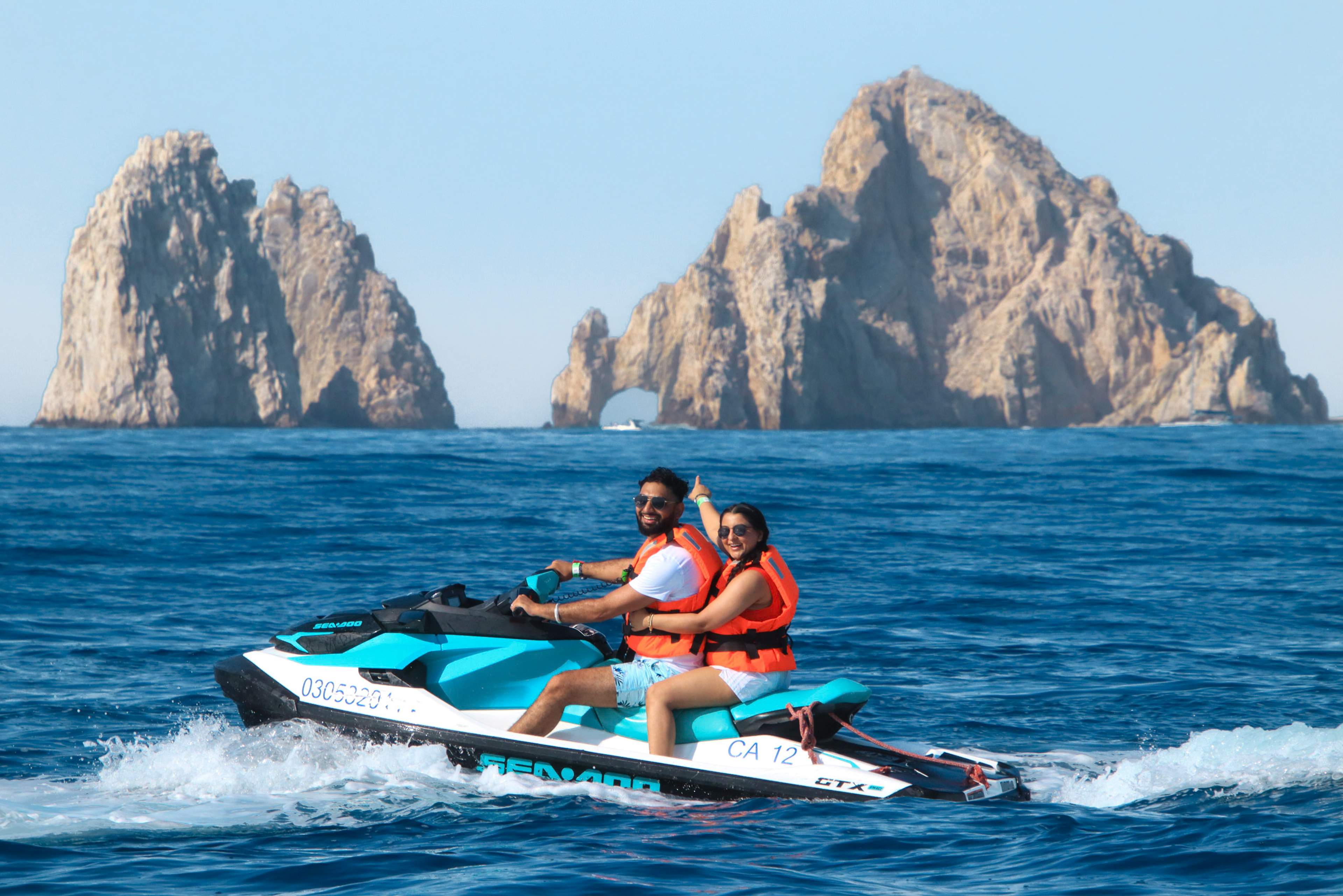 Couple riding on a jet ski past with the Arco in the background