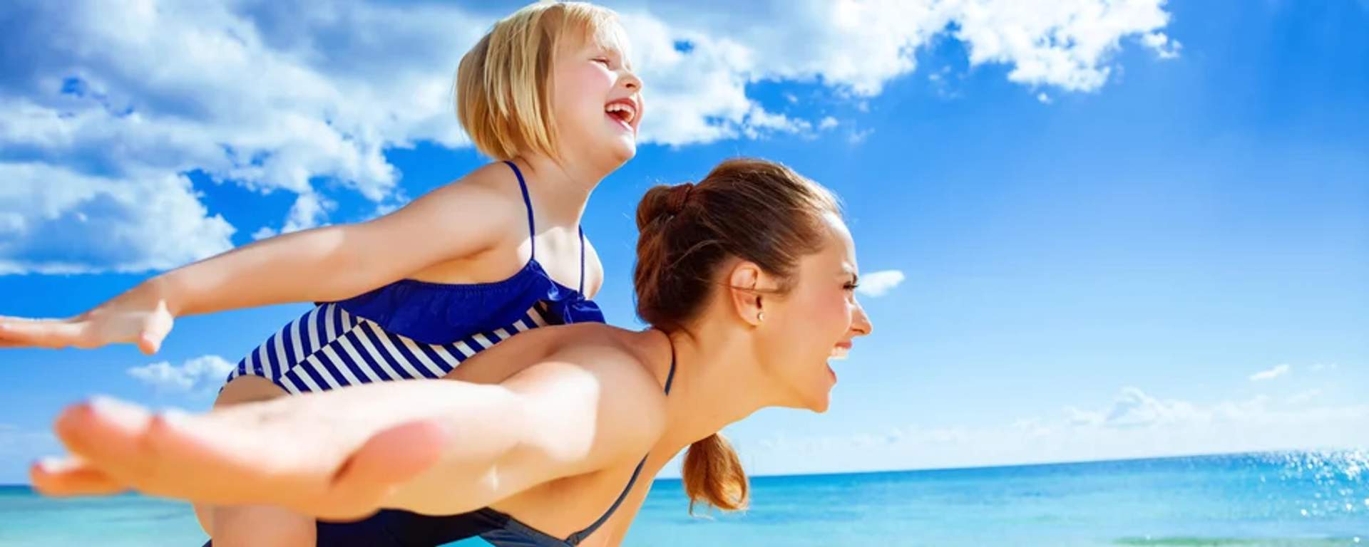 Mother and daughter having fun at the beach  